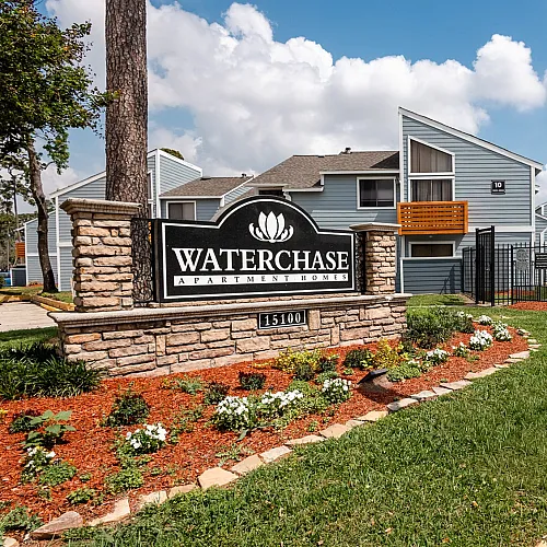 Inviting entrance of Waterchase Apartment Homes, showcasing well-maintained landscaping, modern architecture, and a welcoming community atmosphere.