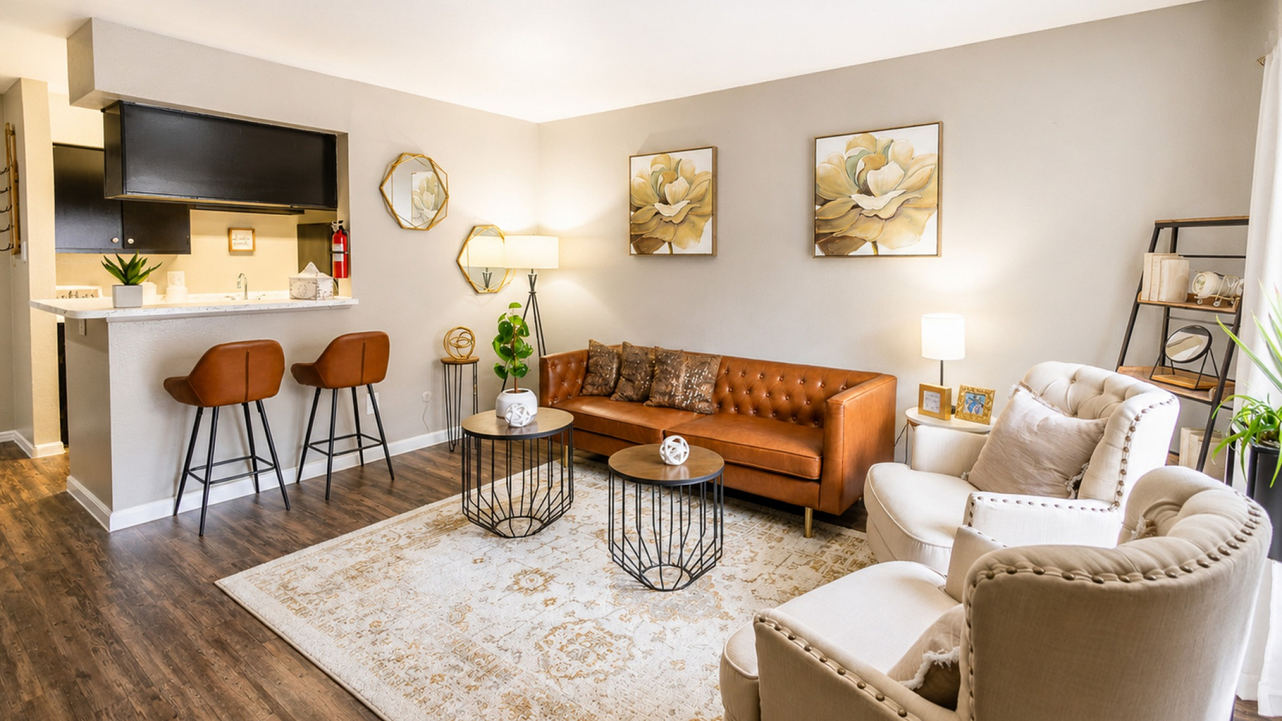 Spacious living room interior at Newport Oaks Apartments in Alvin TX with modern flooring and open kitchen bar seating