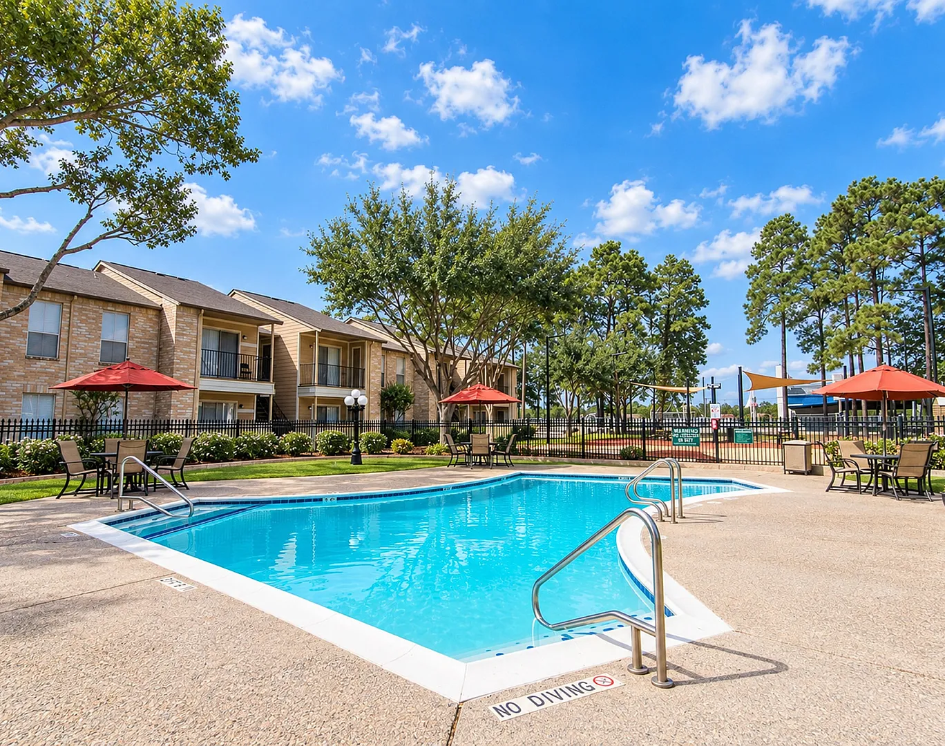 Inviting apartment complex with a sparkling pool, stylish outdoor seating, and vibrant umbrellas, perfect for relaxation and leisure.