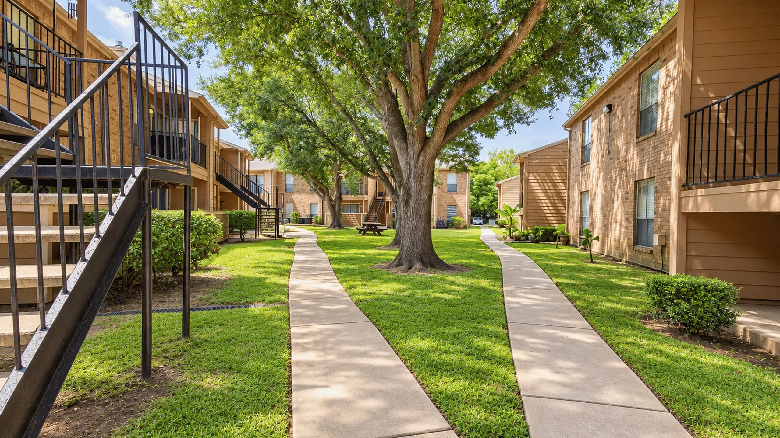 Tree-lined pedestrian walkway between apartment buildings at Meadow Park