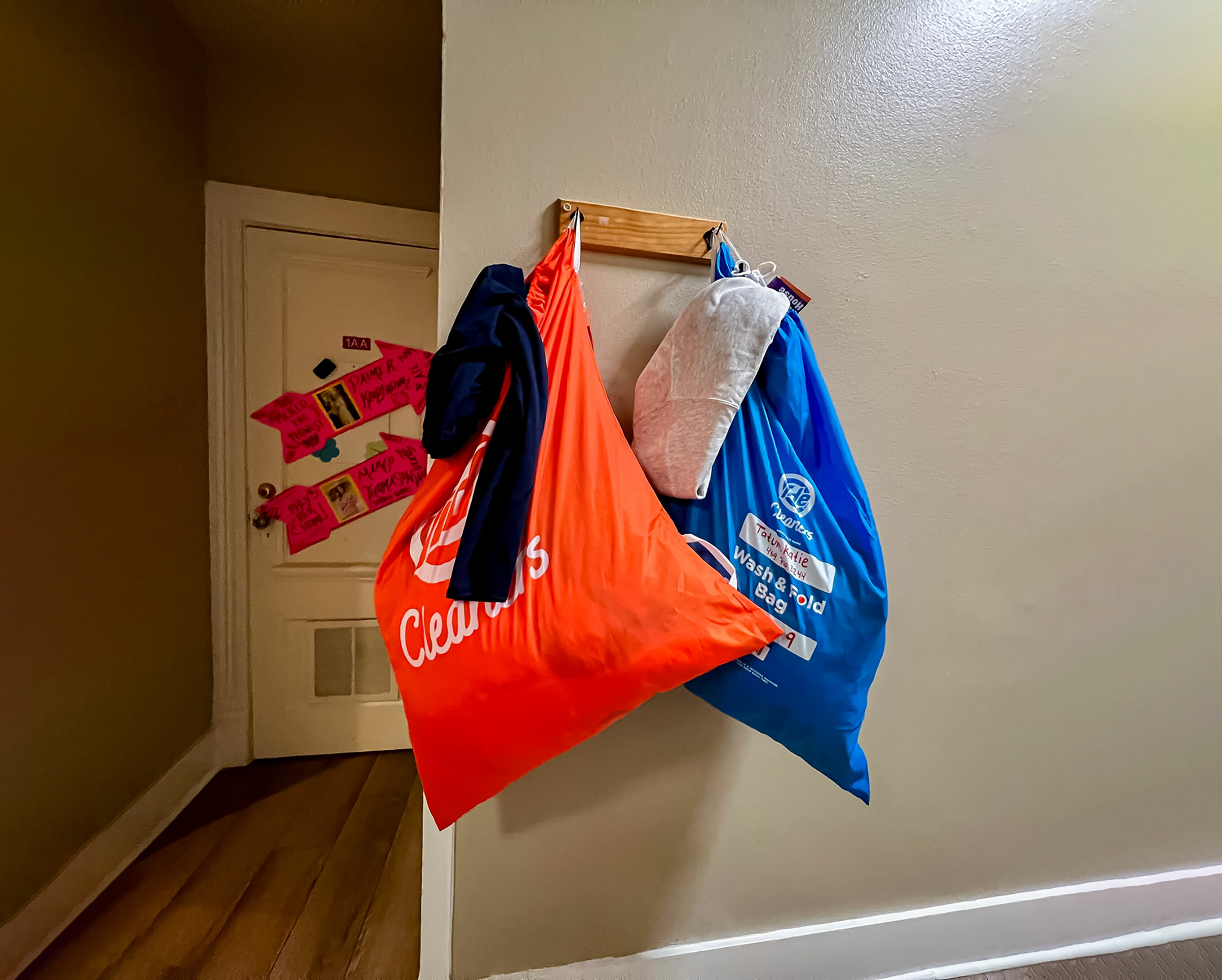 Cozy apartment hallway with vibrant laundry bags hanging on the wall, creating a colorful and welcoming atmosphere.