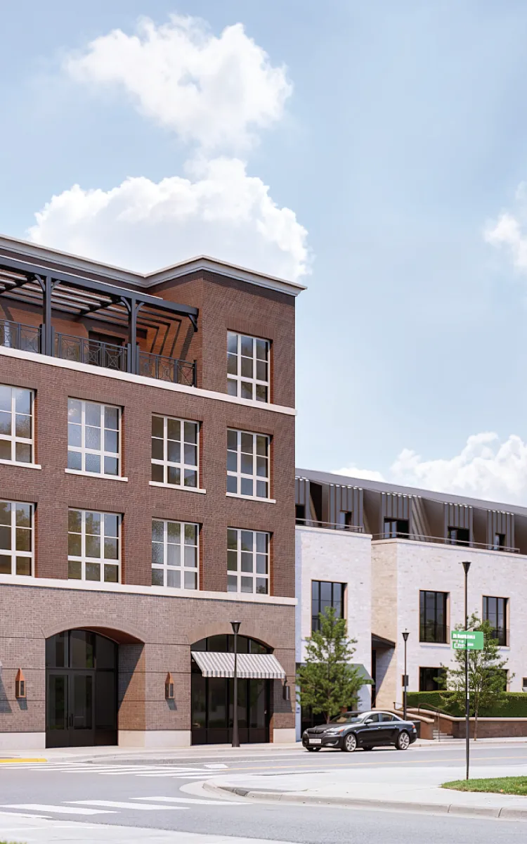Traditional apartment complex with elegant brick facade, large windows, and inviting storefronts on a sunny day.