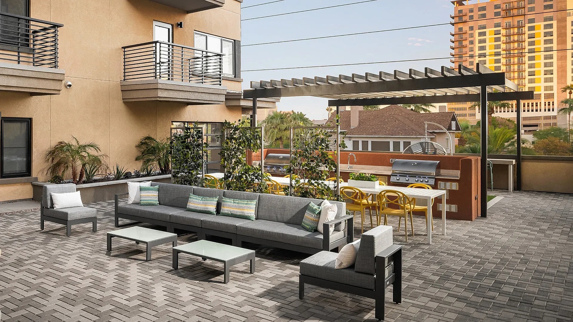 Chic outdoor patio featuring modern seating, a stylish pergola, and a sleek barbecue area, perfect for relaxing and entertaining.