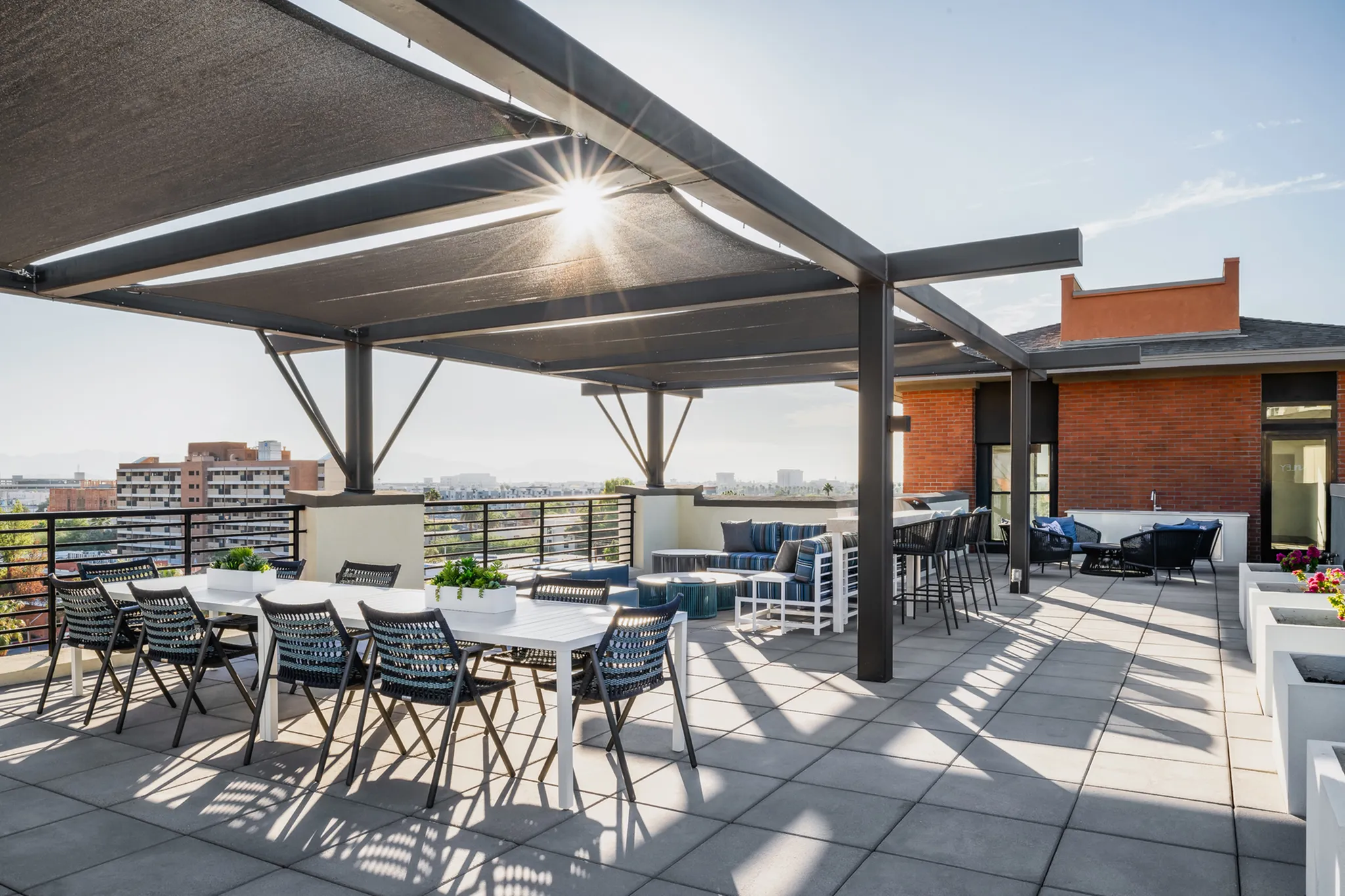 Stunning rooftop terrace with modern pergola, stylish seating, and panoramic city views bathed in sunlight.