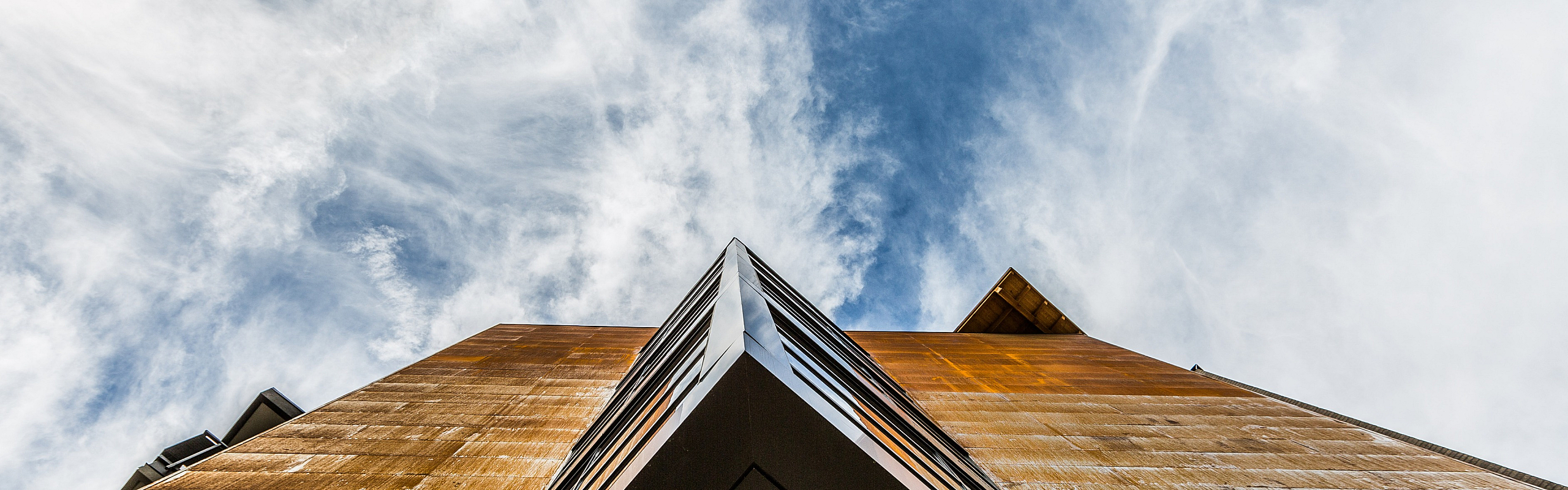Dramatic view of a modern building facade against a vibrant sky, highlighting architectural elegance and urban sophistication.