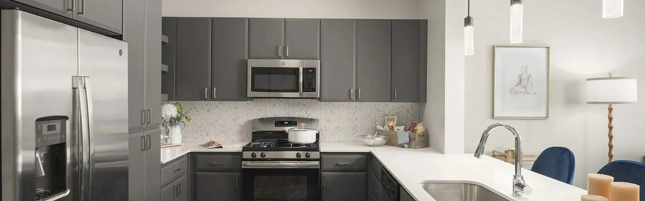 Modern kitchen with sleek stainless steel appliances, elegant pendant lighting, and stylish cabinetry, offering a luxurious culinary space.