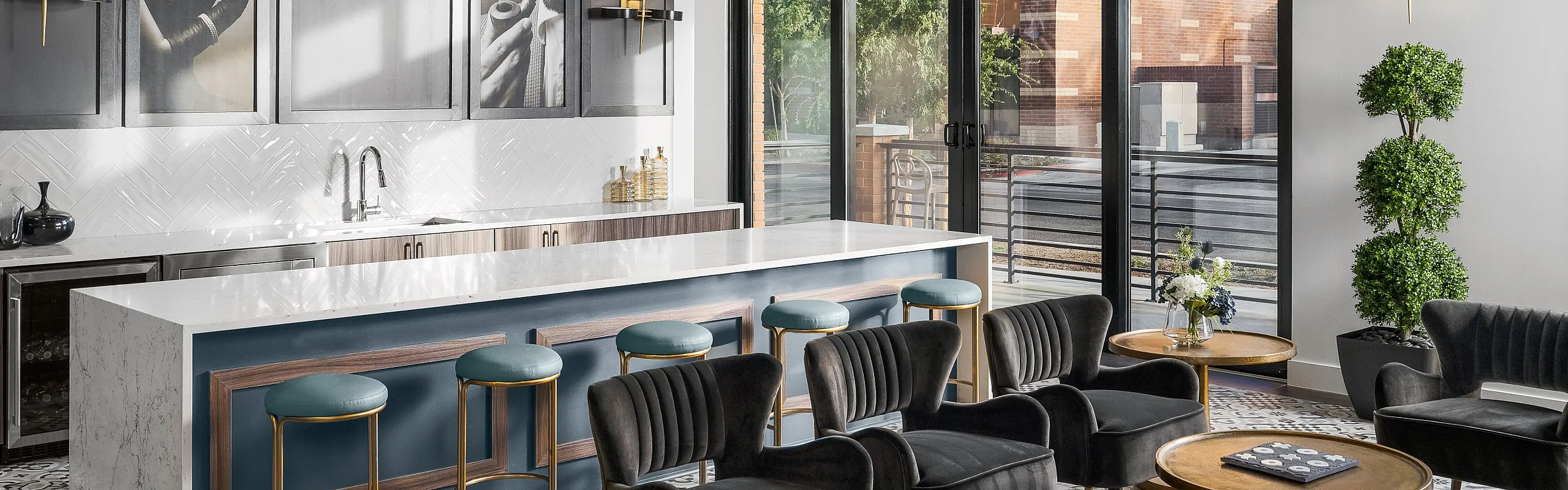 Luxurious modern lounge with velvet seating, elegant gold accents, and large windows offering natural light.
