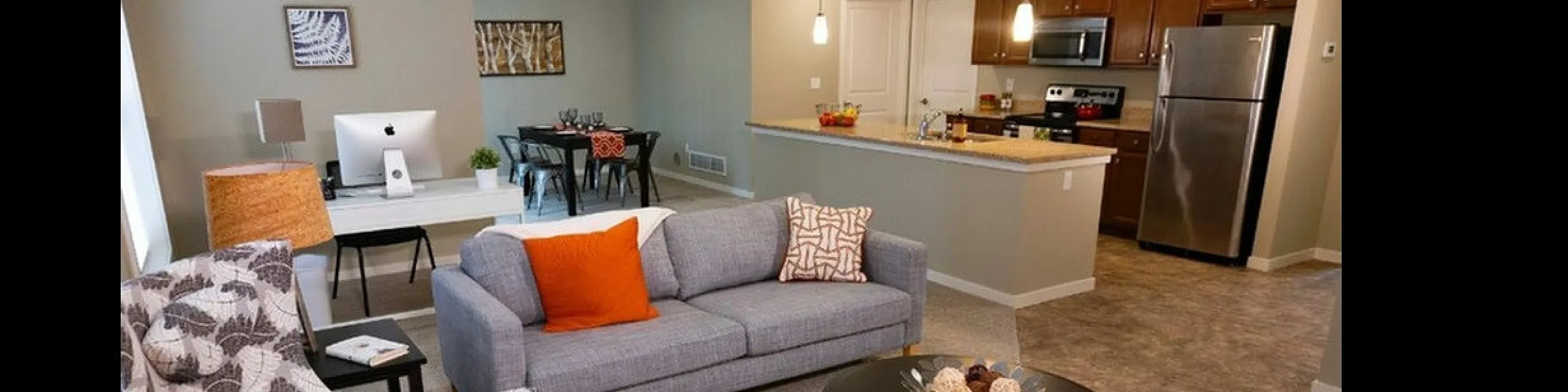 Inviting open-concept living space with modern furniture, stylish decor, and a sleek kitchen overlooking the cozy area.