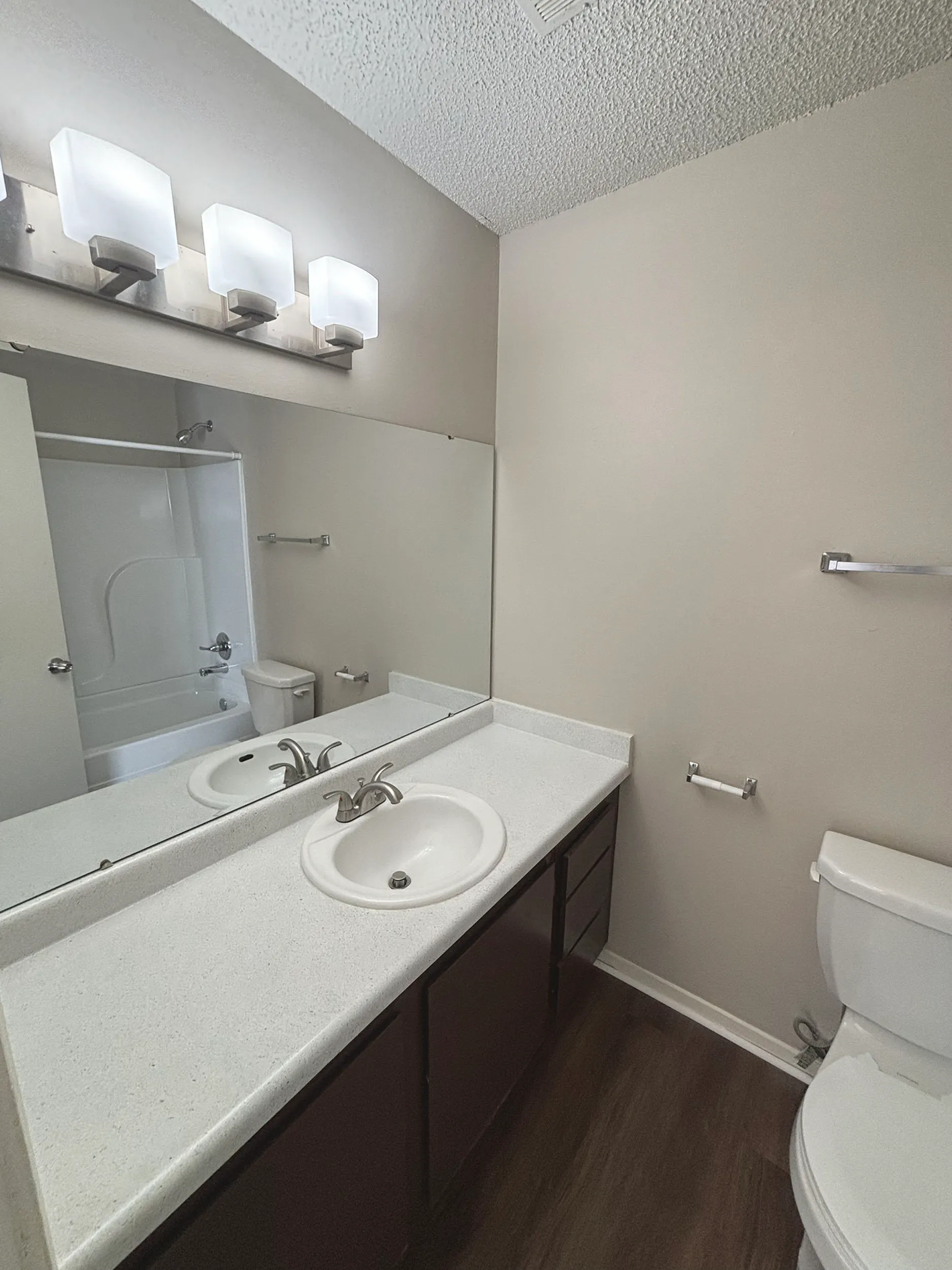 Modern bathroom with elegant vanity, large mirror, and sleek lighting, offering a sophisticated touch.