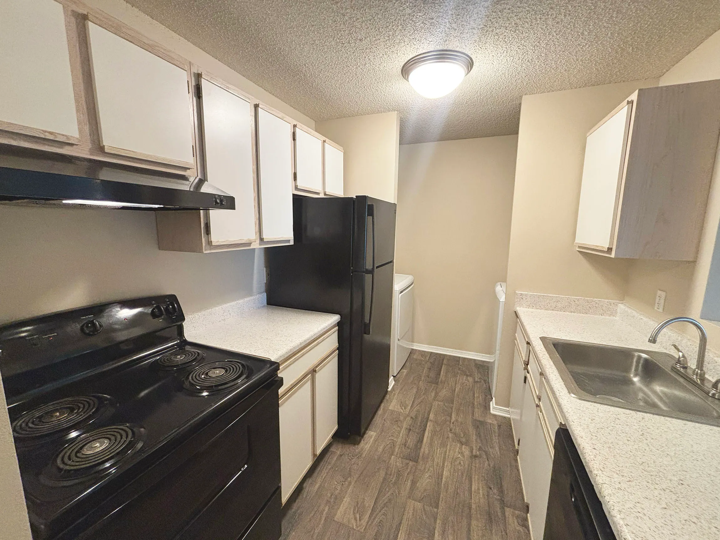 Cozy apartment kitchen with modern appliances, sleek countertops, and ample cabinet space.
