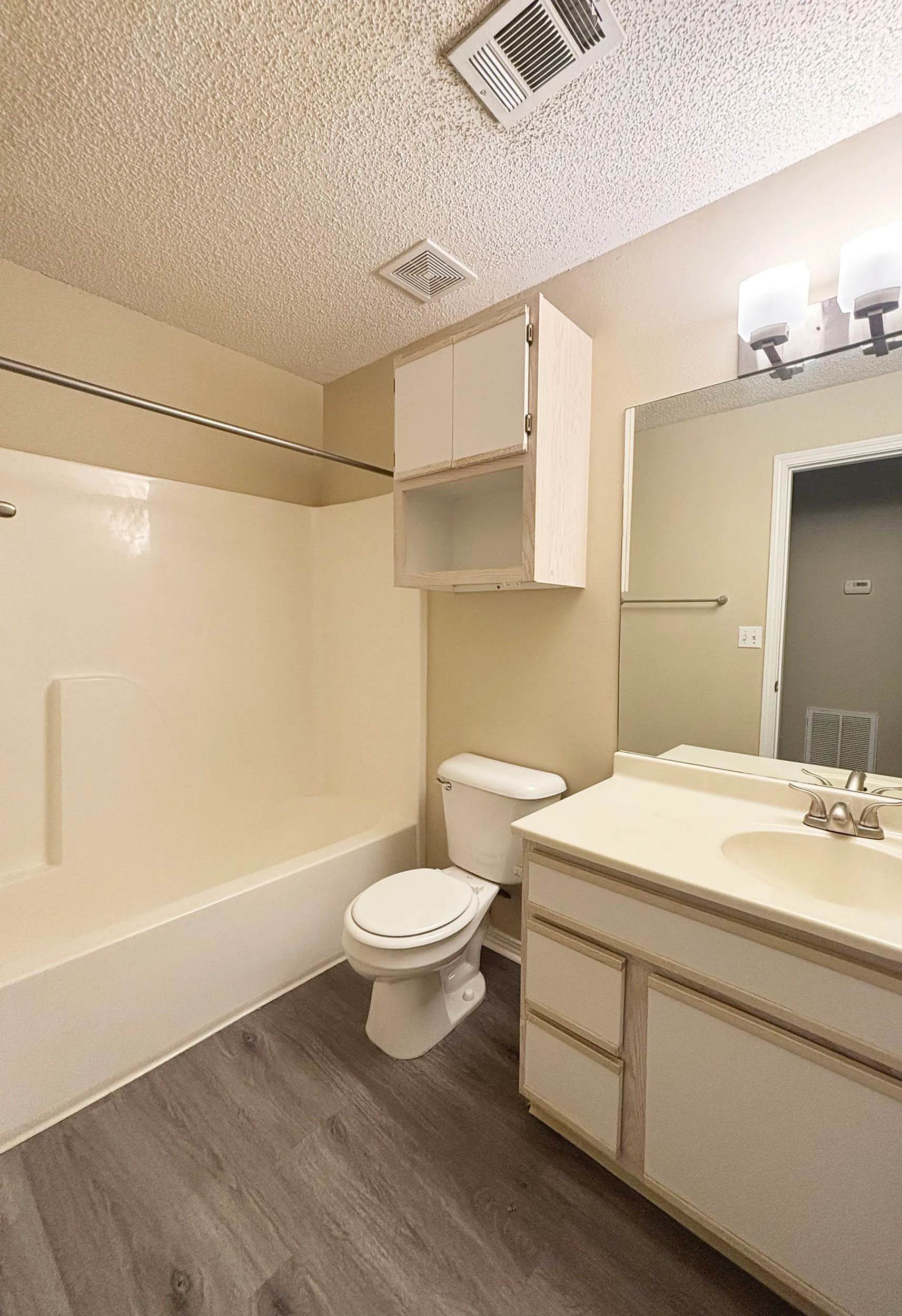 Cozy bathroom featuring modern fixtures, ample storage, and a sleek vanity complemented by warm wood flooring.