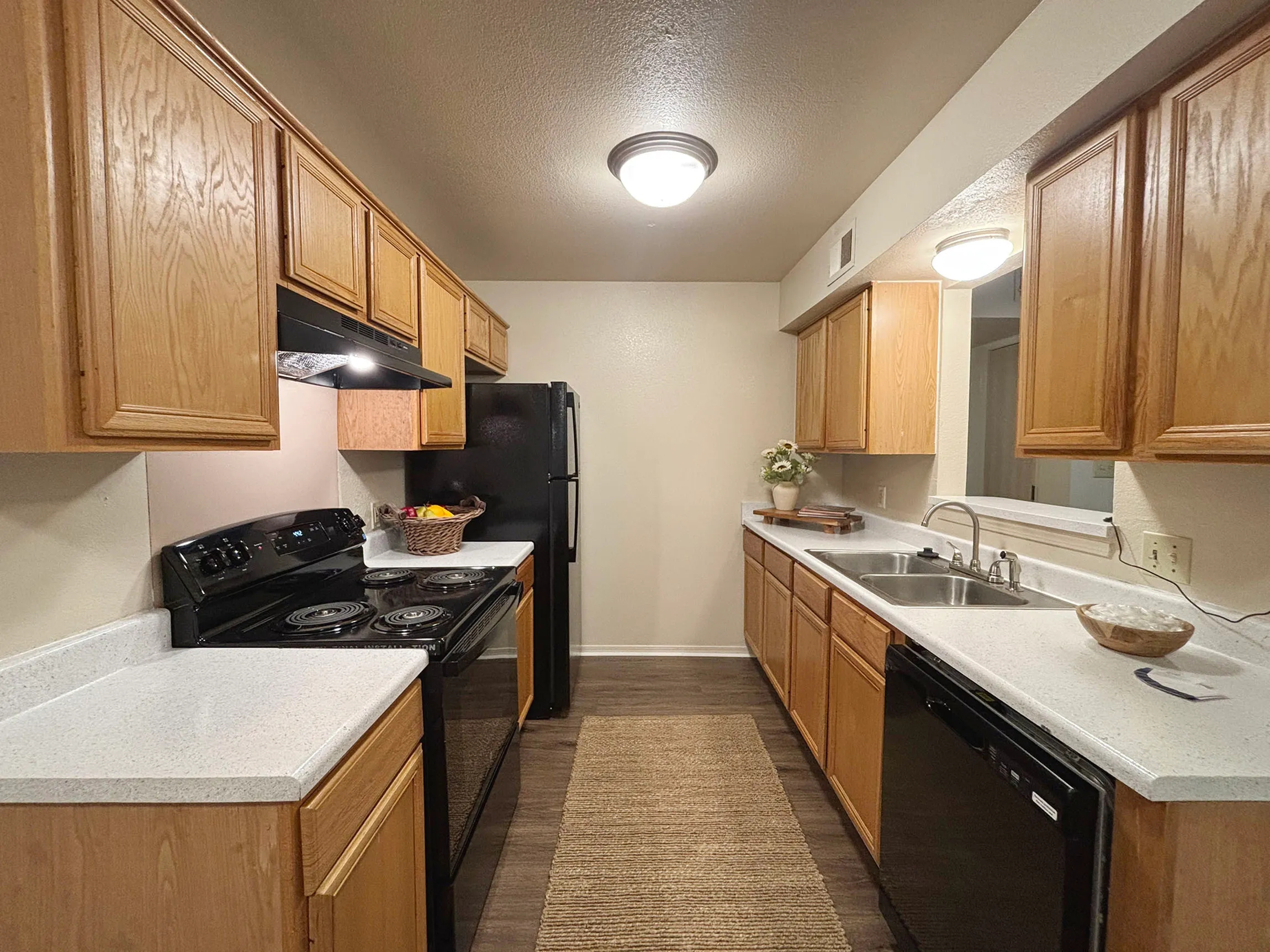 Contemporary kitchen with sleek black appliances, warm wooden cabinetry, and ample counter space, perfect for modern culinary adventures.