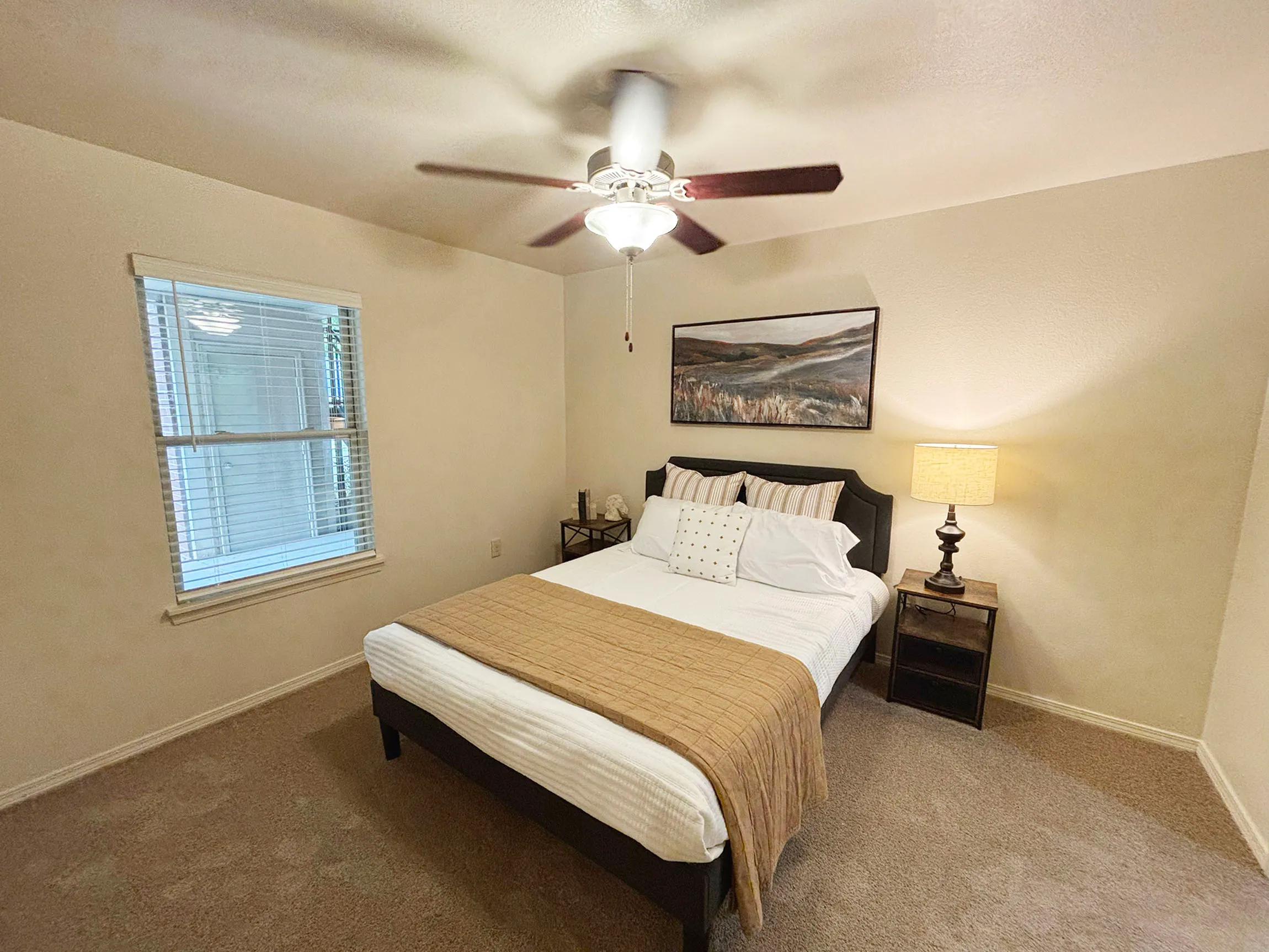 Inviting bedroom featuring a cozy double bed, stylish decor, and natural light from a large window.
