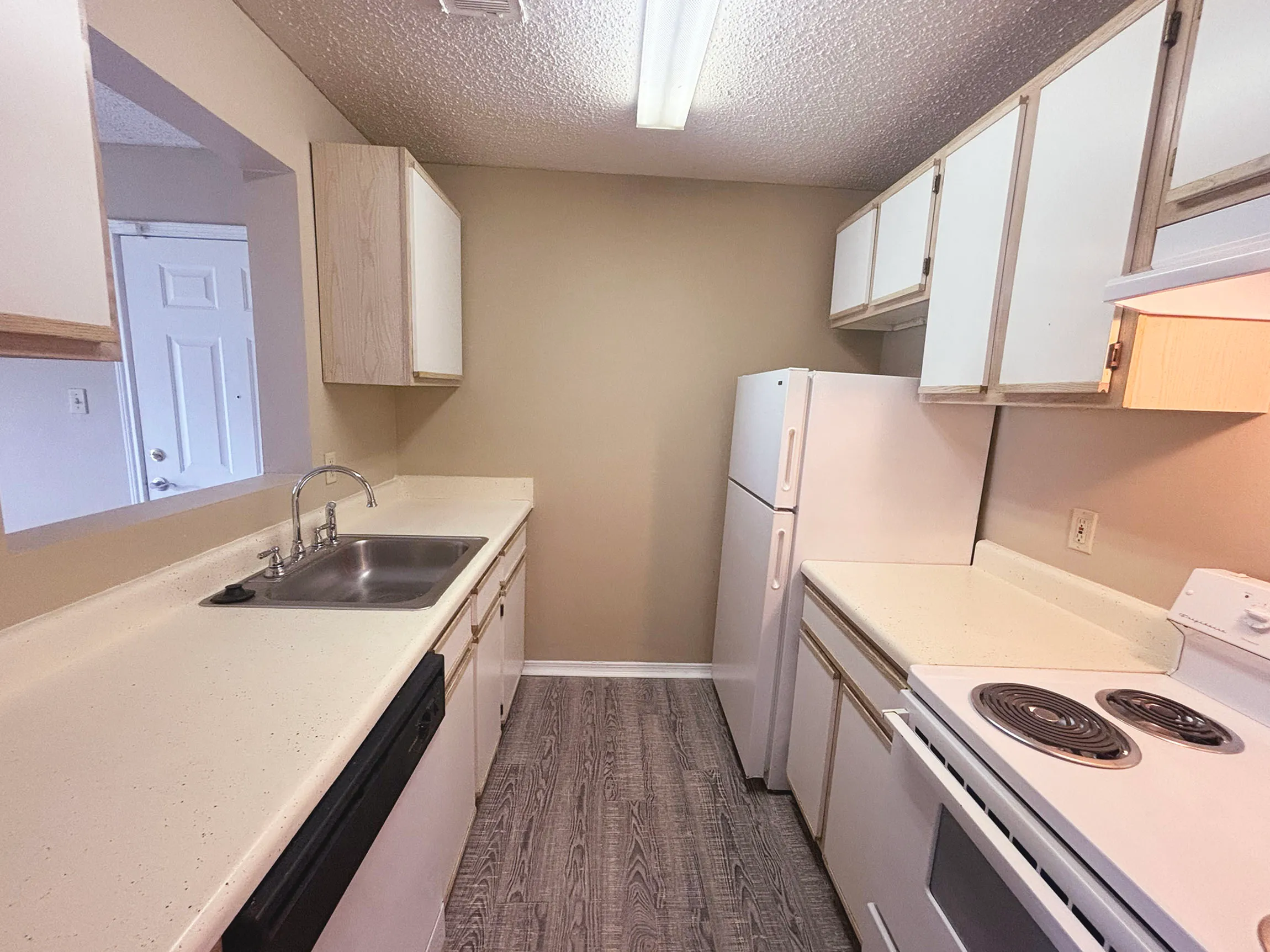 Charming kitchen with sleek countertops, ample cabinet space, and modern appliances in a cozy apartment setting.