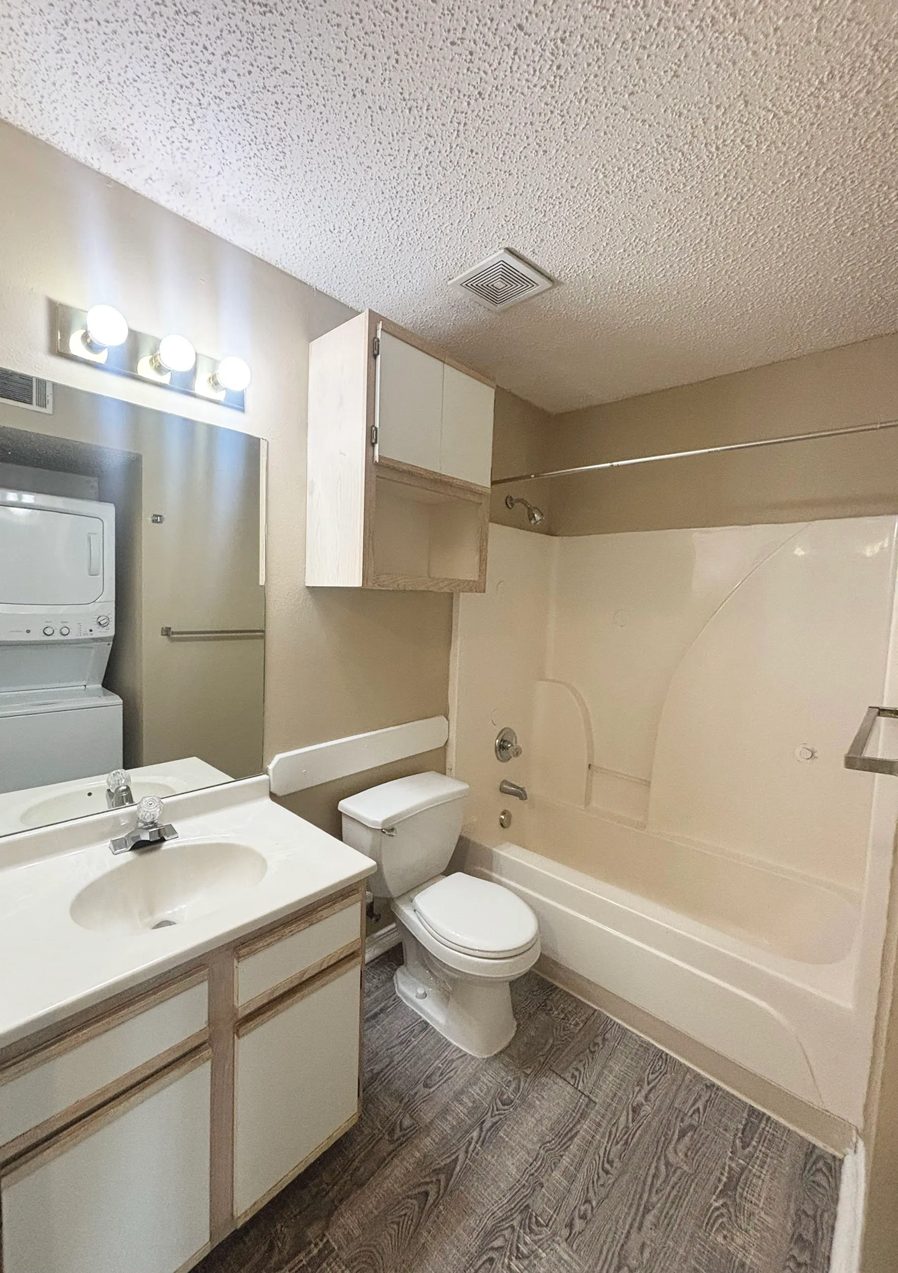 Contemporary bathroom with sleek design, featuring a clean sink, bathtub, and integrated laundry facilities with modern lighting.