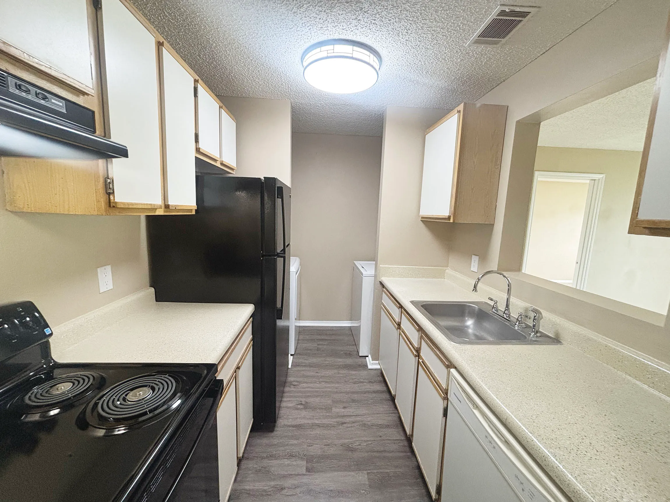 Contemporary kitchen with sleek black appliances, spacious countertops, and ample cabinet storage, perfect for modern living.