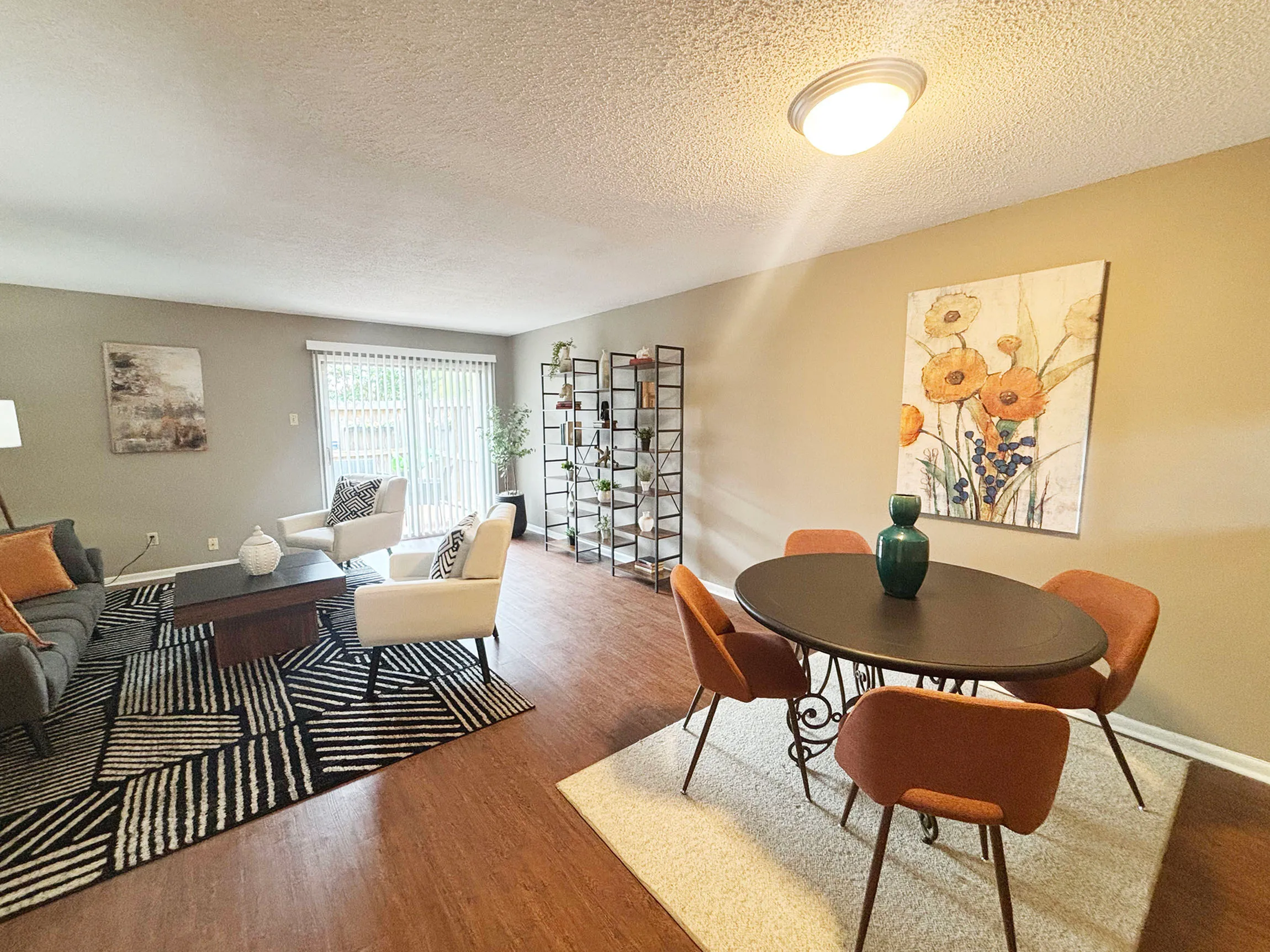 Inviting living and dining area with stylish decor, featuring a cozy seating arrangement, elegant dining table, and natural light pouring through large windows.
