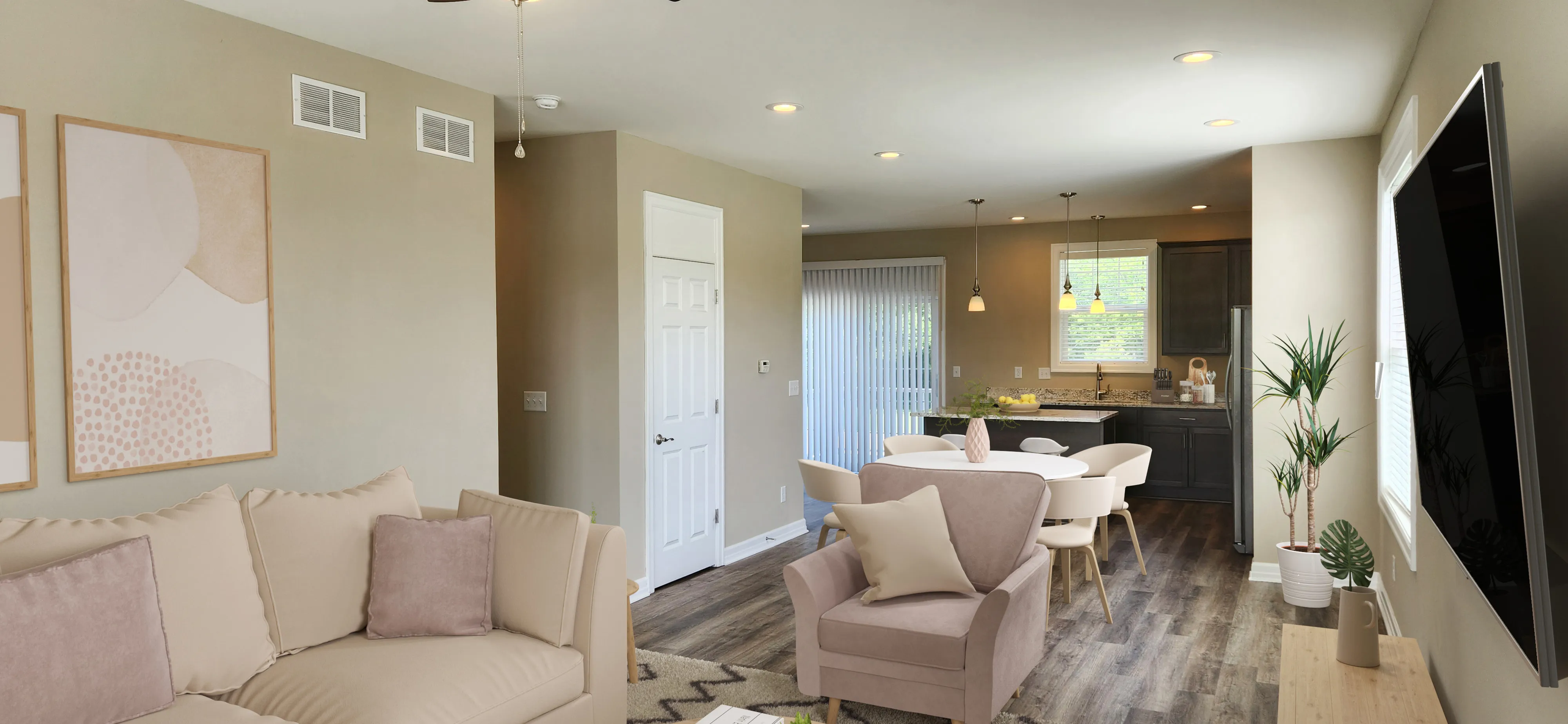 Bright open-concept living space with cozy seating area, modern dining set, and stylish kitchen featuring dark cabinets and warm accents.