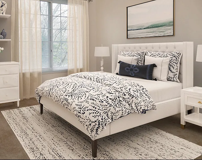 Chic bedroom with elegant decor, featuring a cozy bed with patterned bedding, stylish white dresser, and serene natural light.
