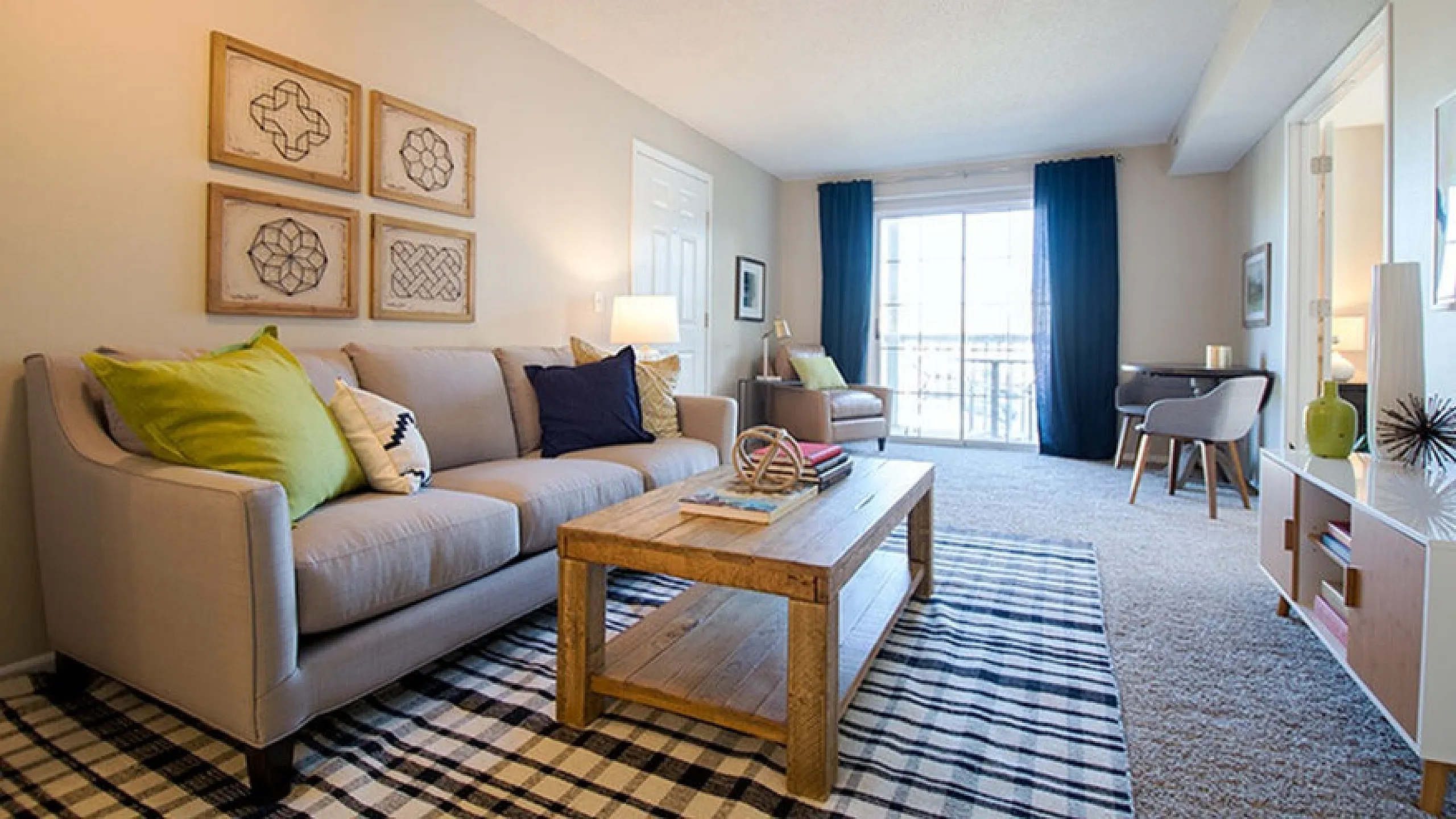 Inviting living room with elegant decor, plush sofa, chic coffee table, and vibrant natural light from large windows.