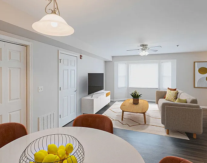 Bright and modern living room with elegant decor, cozy seating, flat-screen TV, and dining area with a bowl of fresh lemons. Perfect for stylish urban living.