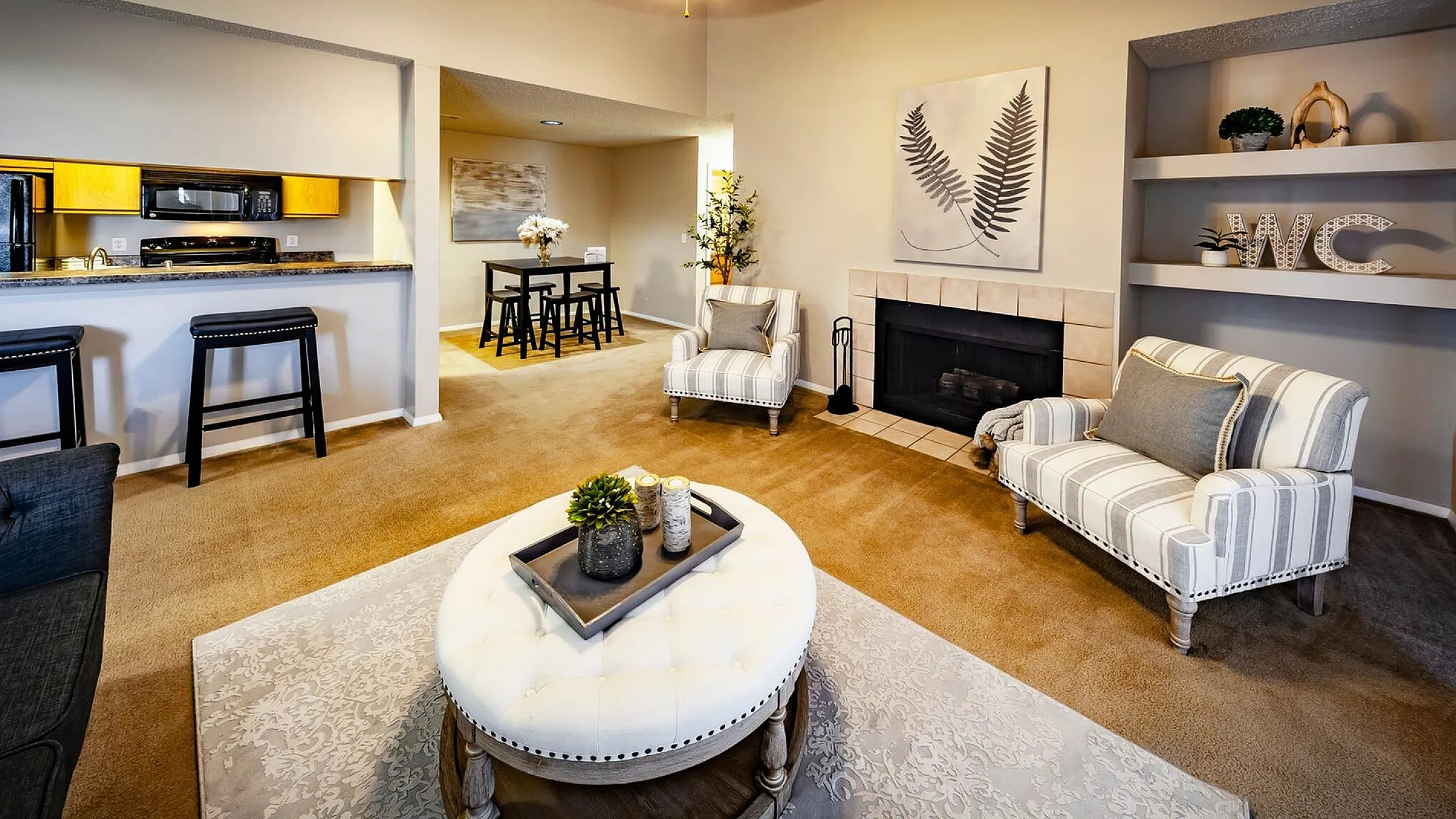 Charming living space with cozy fireplace, elegant seating, and a modern kitchen with a breakfast bar, perfect for entertaining.