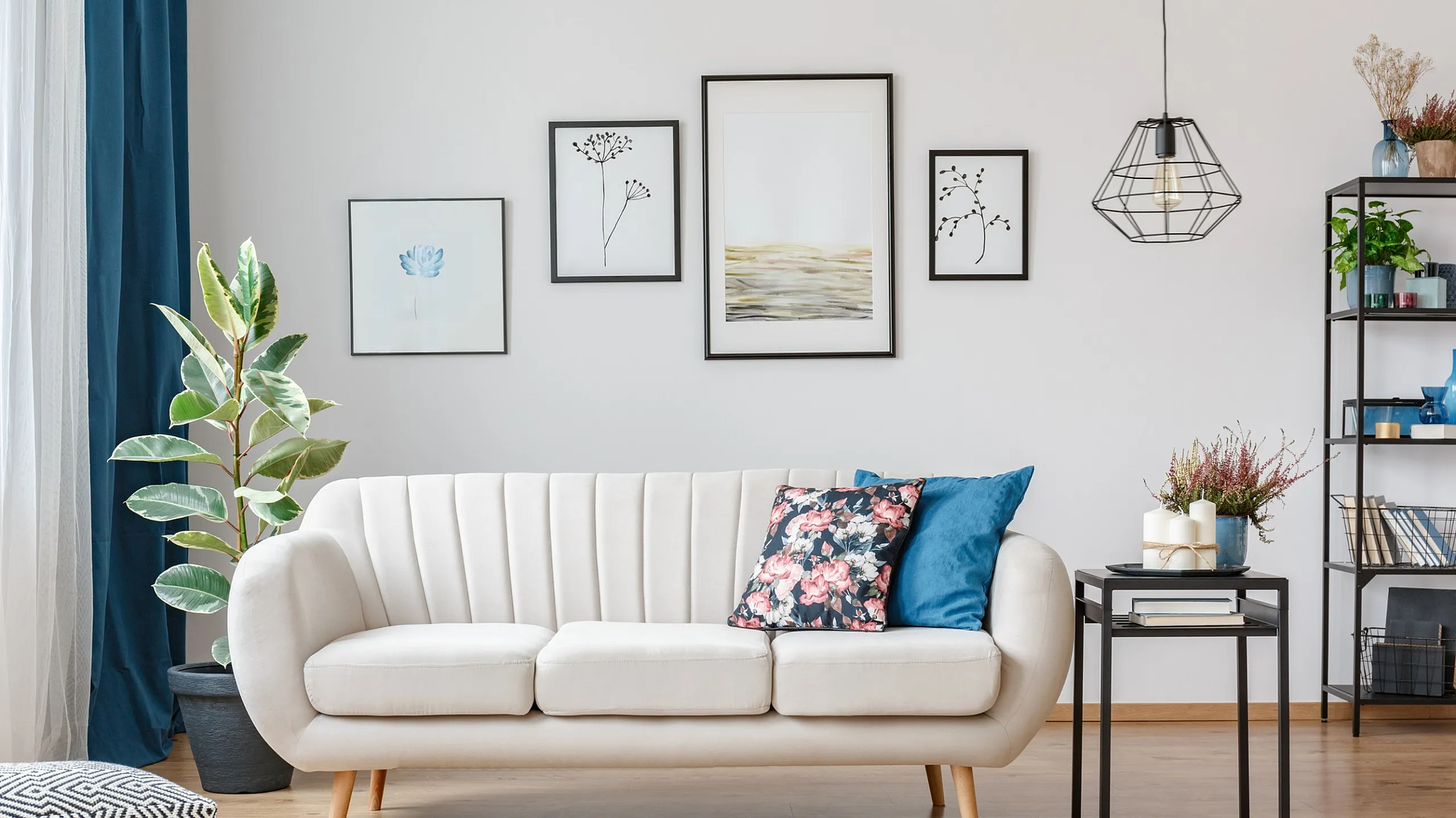 Bright and inviting living room with elegant white sofa, artistic wall decor, and chic modern accents.