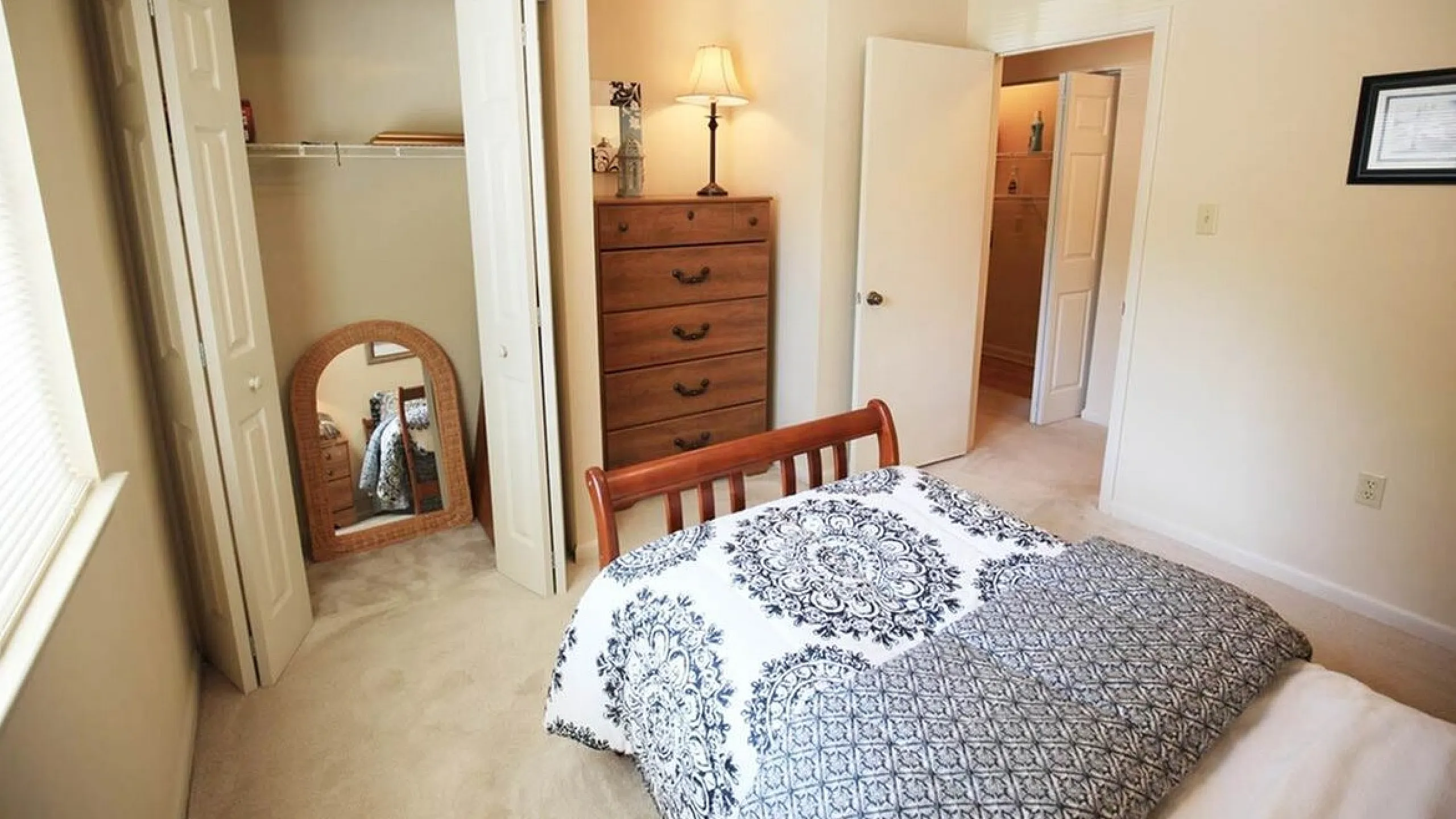 Inviting bedroom with cozy bed, ornate bedding, spacious closet, and warm lighting for a relaxing atmosphere.