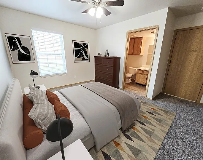 Inviting bedroom with plush carpet, modern artwork, and ensuite bathroom, designed for comfort and style.