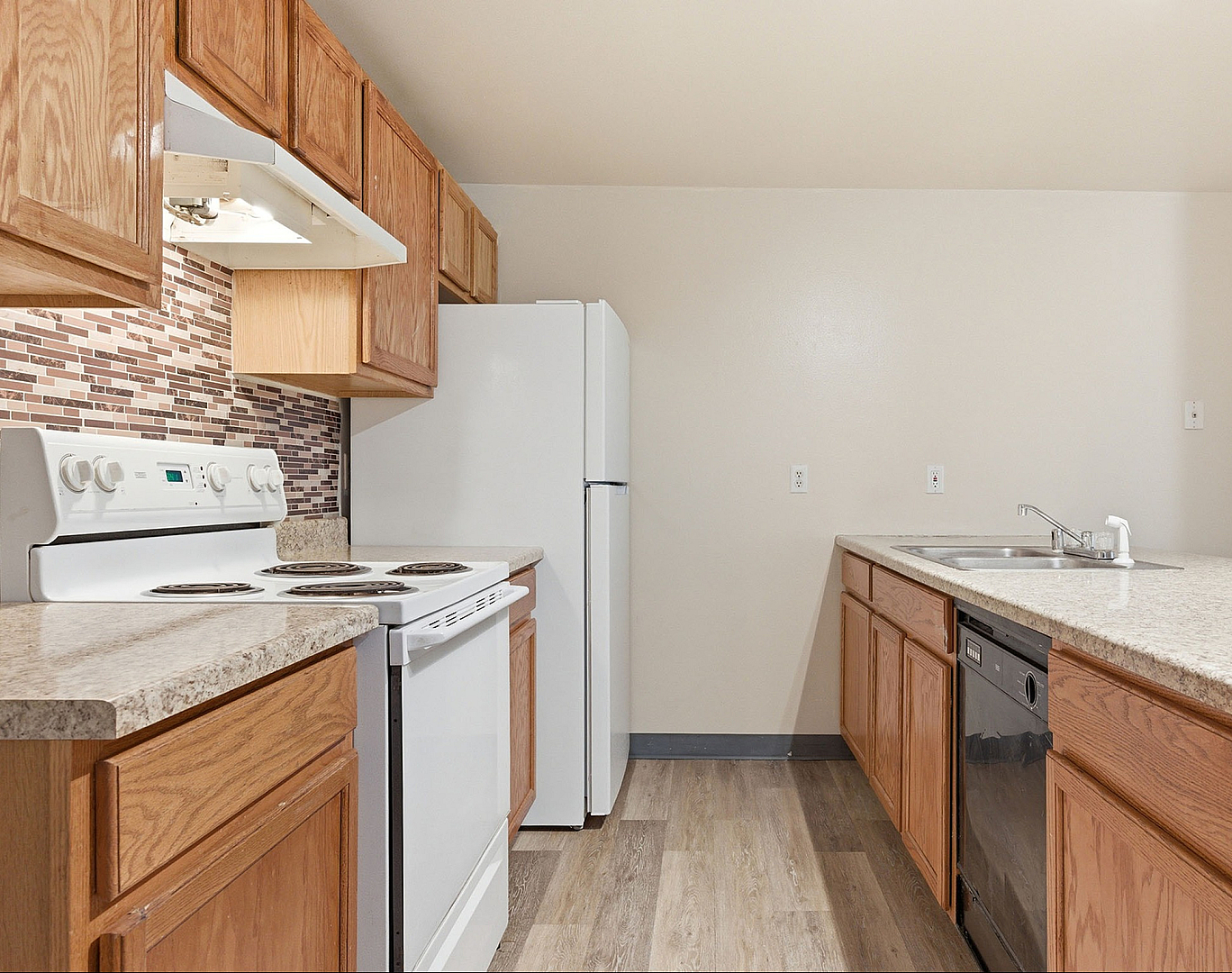 Modern kitchen featuring sleek countertops, wooden cabinetry, and appliances including a stove and dishwasher, perfect for culinary creativity.