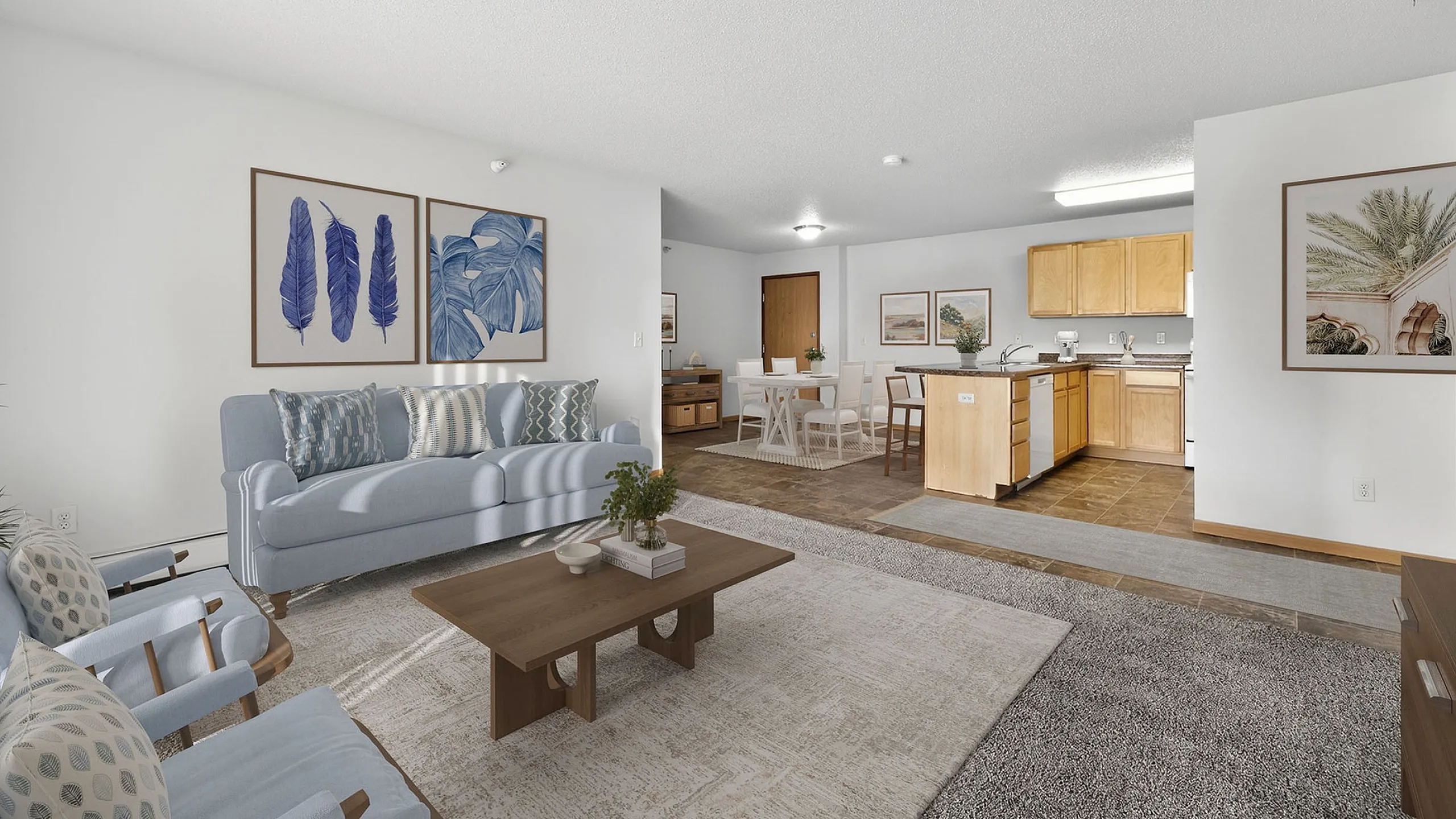 Bright and inviting open-concept living room with modern kitchen, stylish light blue furniture, and elegant decor, perfect for comfortable living.