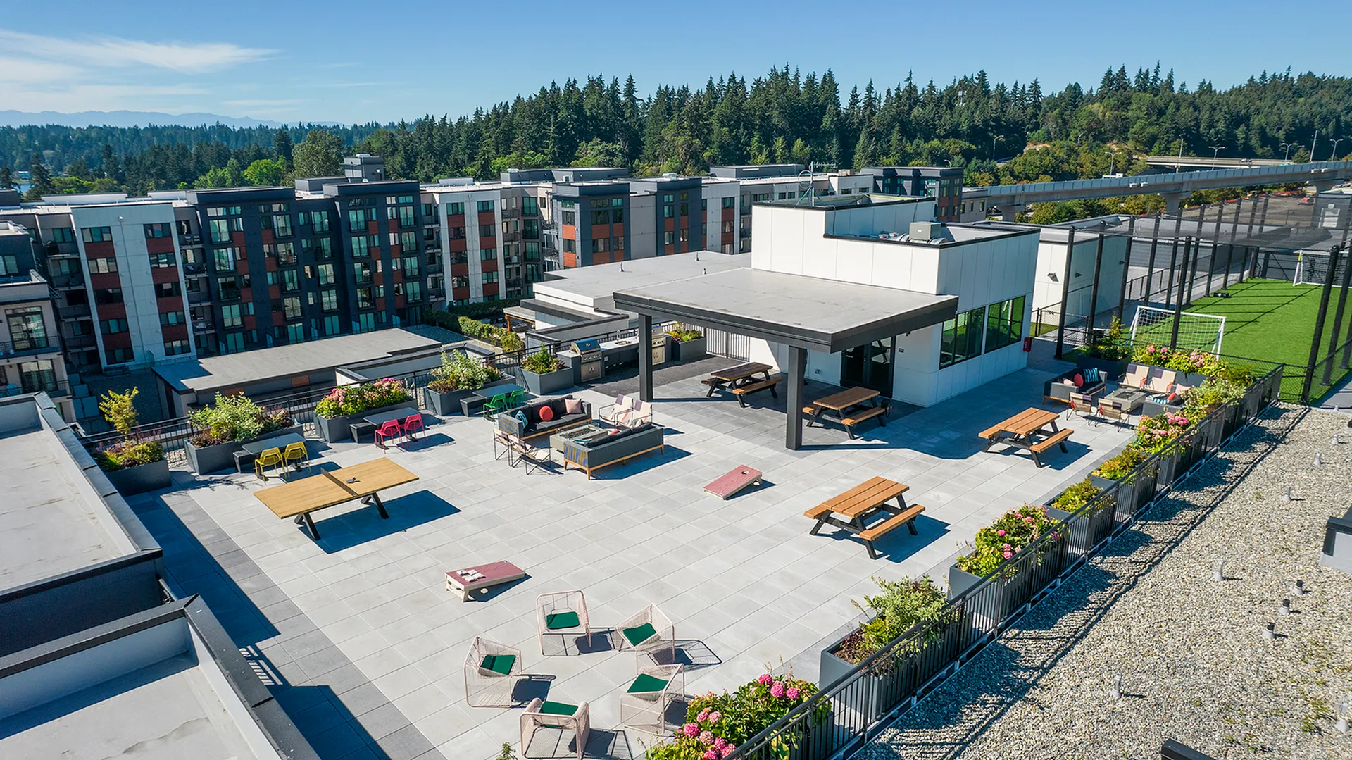 Expansive rooftop terrace offering stylish outdoor seating, lush greenery, and panoramic skyline views, ideal for leisure and social gatherings.