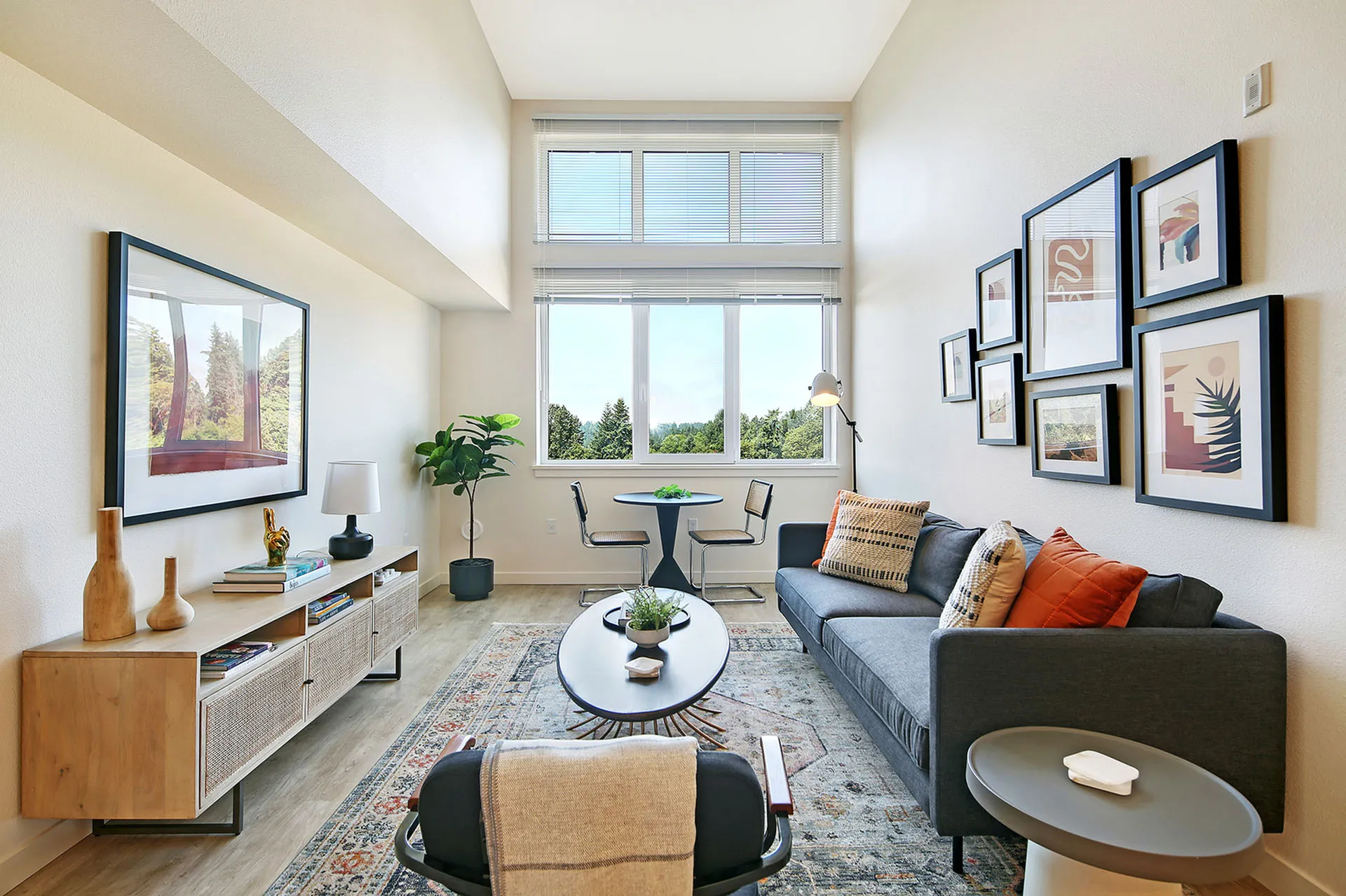 Bright and modern living room with large windows, stylish furniture, and vibrant decor, offering a cozy and inviting atmosphere with scenic outdoor views from expansive windows.