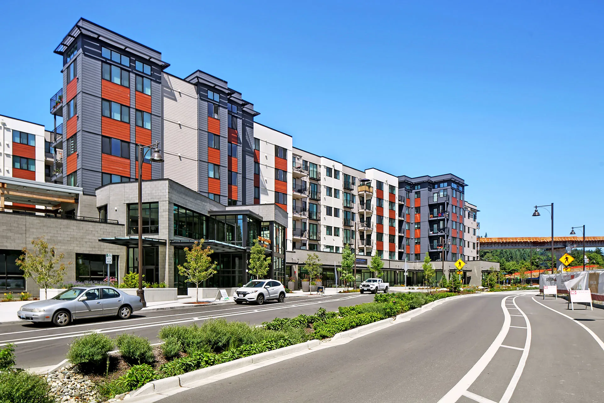 Contemporary apartment complex with vibrant exterior design, featuring sleek glass accents and stylish balconies in an urban setting.
