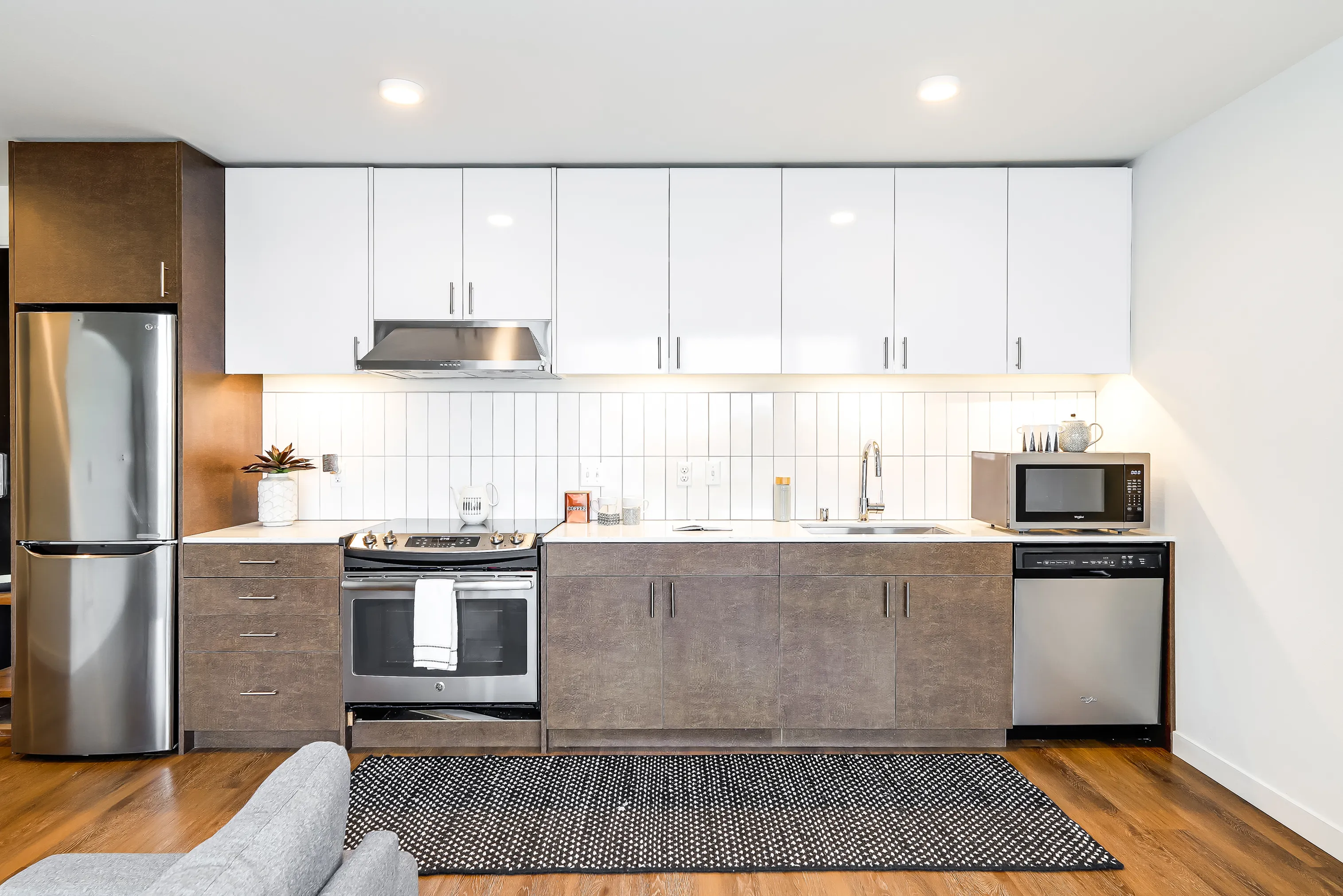Chic modern kitchen featuring sleek stainless steel appliances, minimalist cabinetry, and elegant wood flooring.