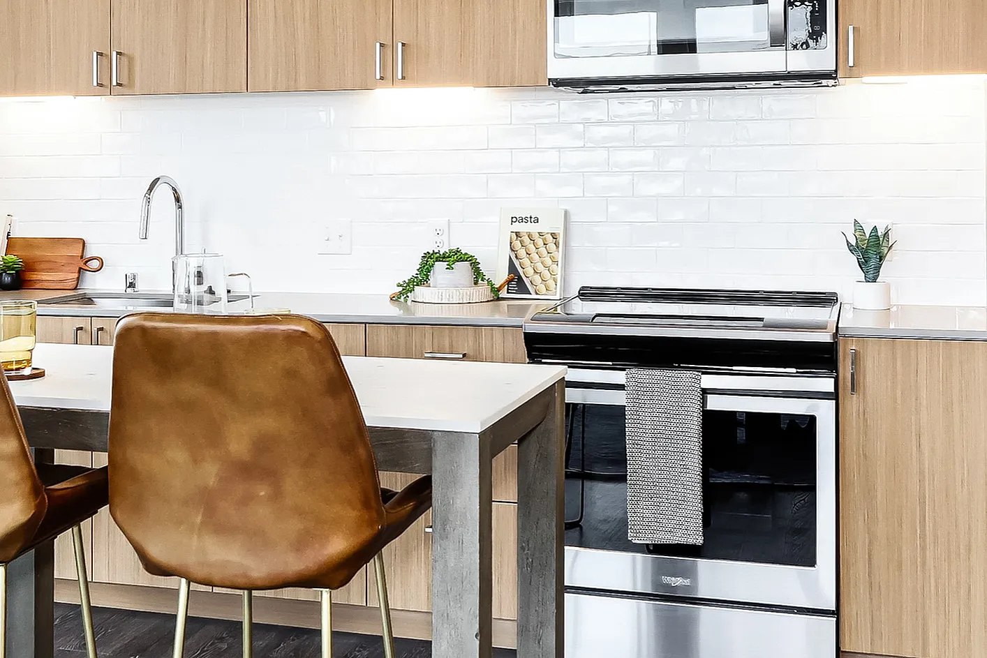 Modern kitchen with sleek stainless steel appliances, elegant wood cabinets, and a bright window view.