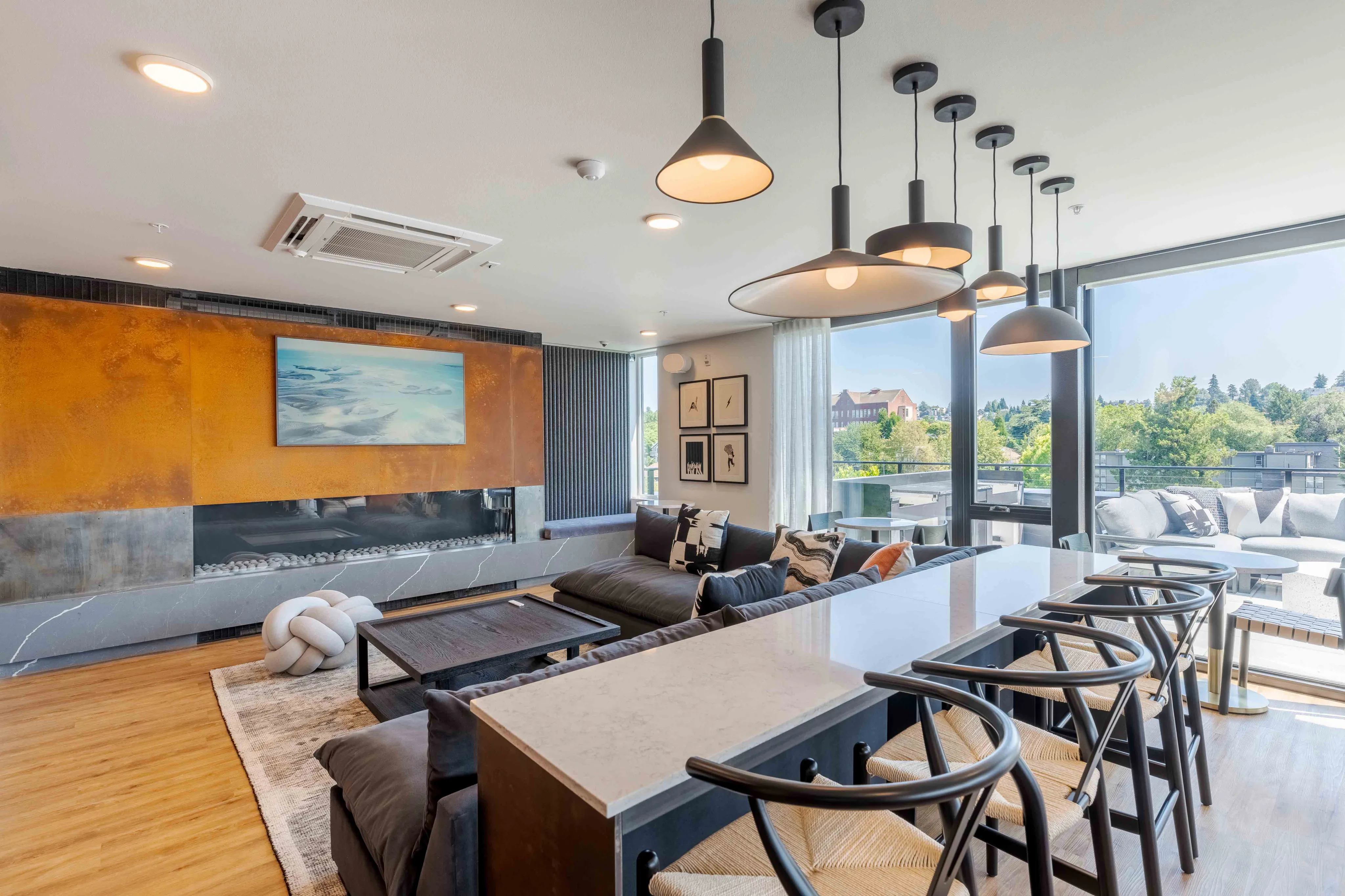 Modern living space with sleek pendant lighting, elegant decor, and panoramic views from large windows, ideal for stylish urban living.