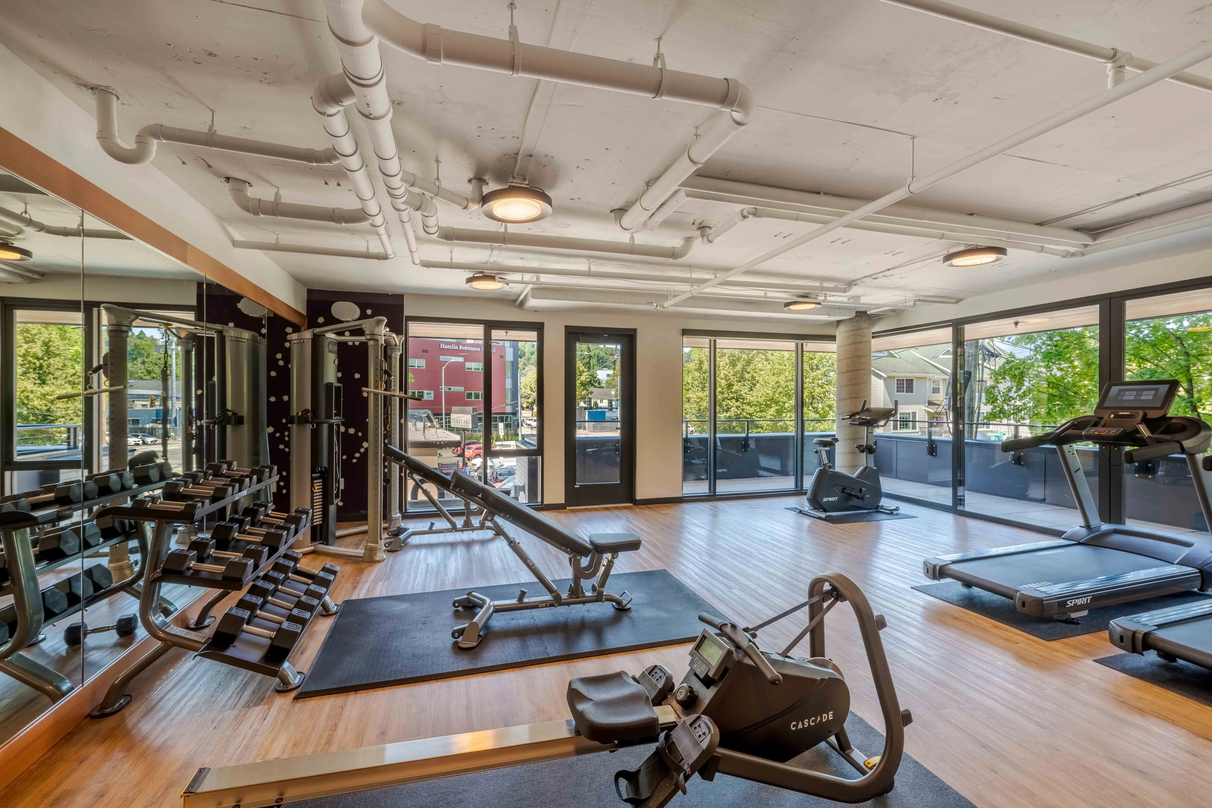 Bright, modern fitness center featuring state-of-the-art gym equipment and large windows showcasing a scenic view.