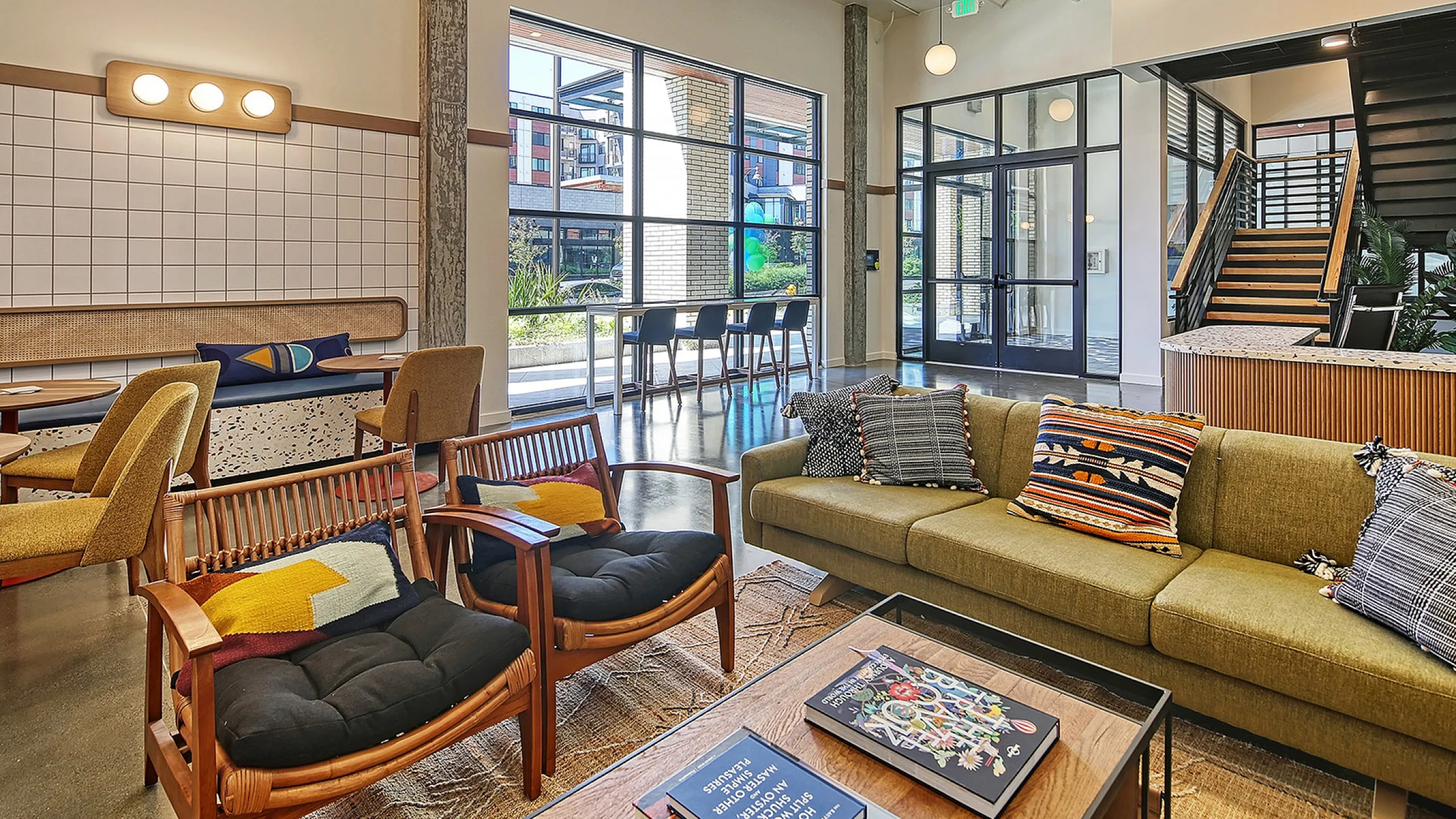 Modern communal living area with stylish seating, vibrant decor, and abundant natural light, highlighting a chic and inviting apartment ambiance.