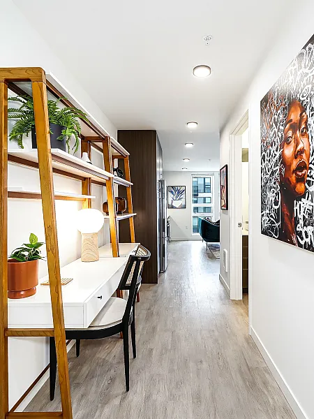 Bright, artistic hallway with modern art and sleek decor, leading to a cozy living space.