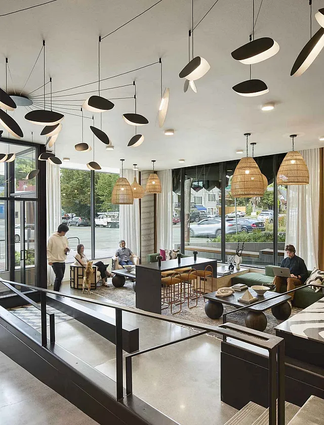 Elegant modern lobby with stylish lighting, cozy seating areas, and large windows offering natural light and views of the city.