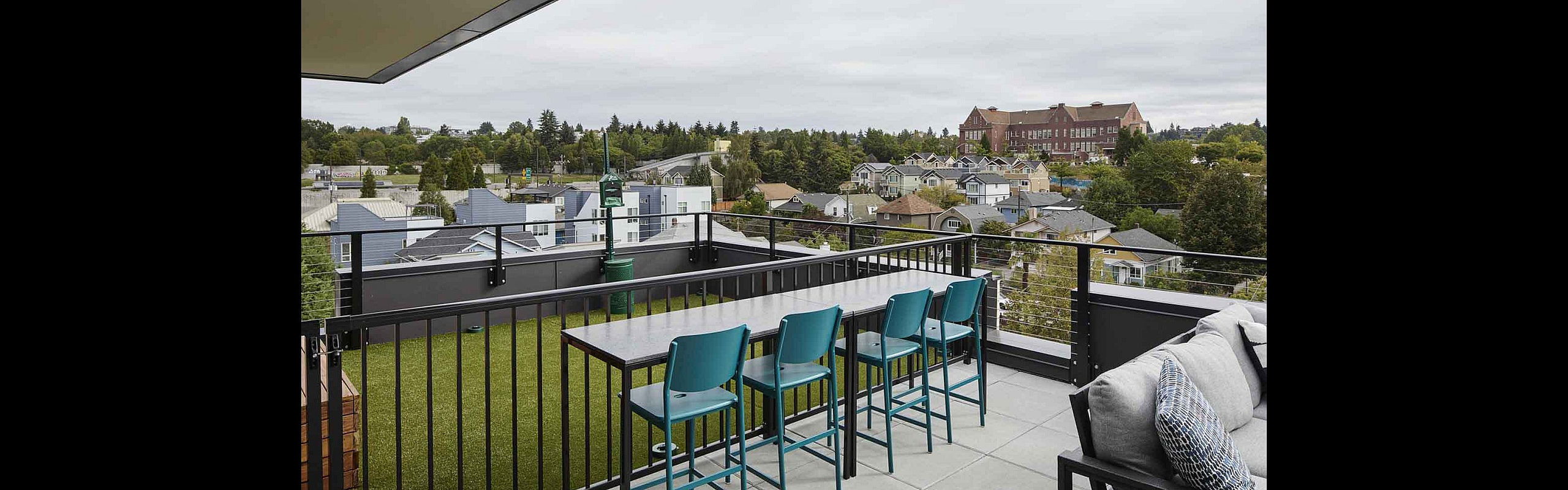 Chic apartment balcony with modern bar seating and scenic neighborhood views, perfect for relaxation and entertaining.