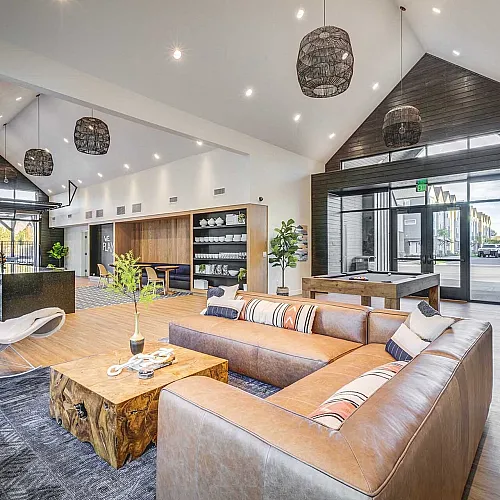 Bright and spacious living area with modern furnishings, high ceilings, and stylish decor, featuring a cozy lounge space and large windows for plentiful natural light.