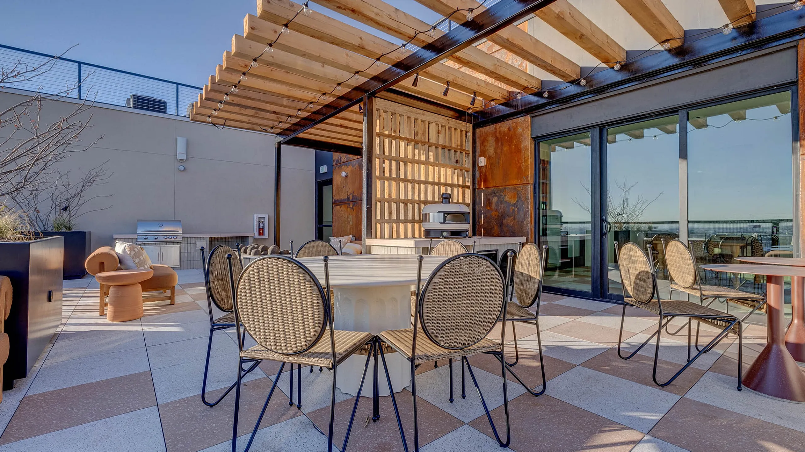 Elegant rooftop terrace featuring modern seating under a stylish pergola, perfect for entertaining and relaxation.