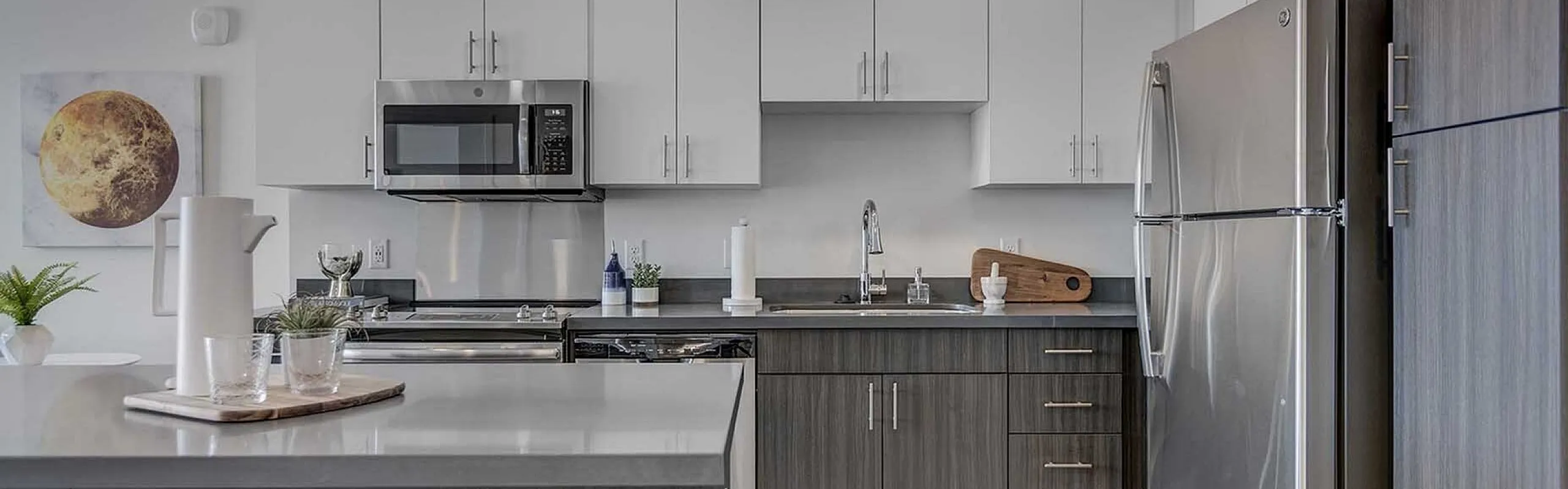Modern kitchen boasting sleek gray countertops, stainless steel appliances, and elegant cabinets, perfect for culinary enthusiasts.