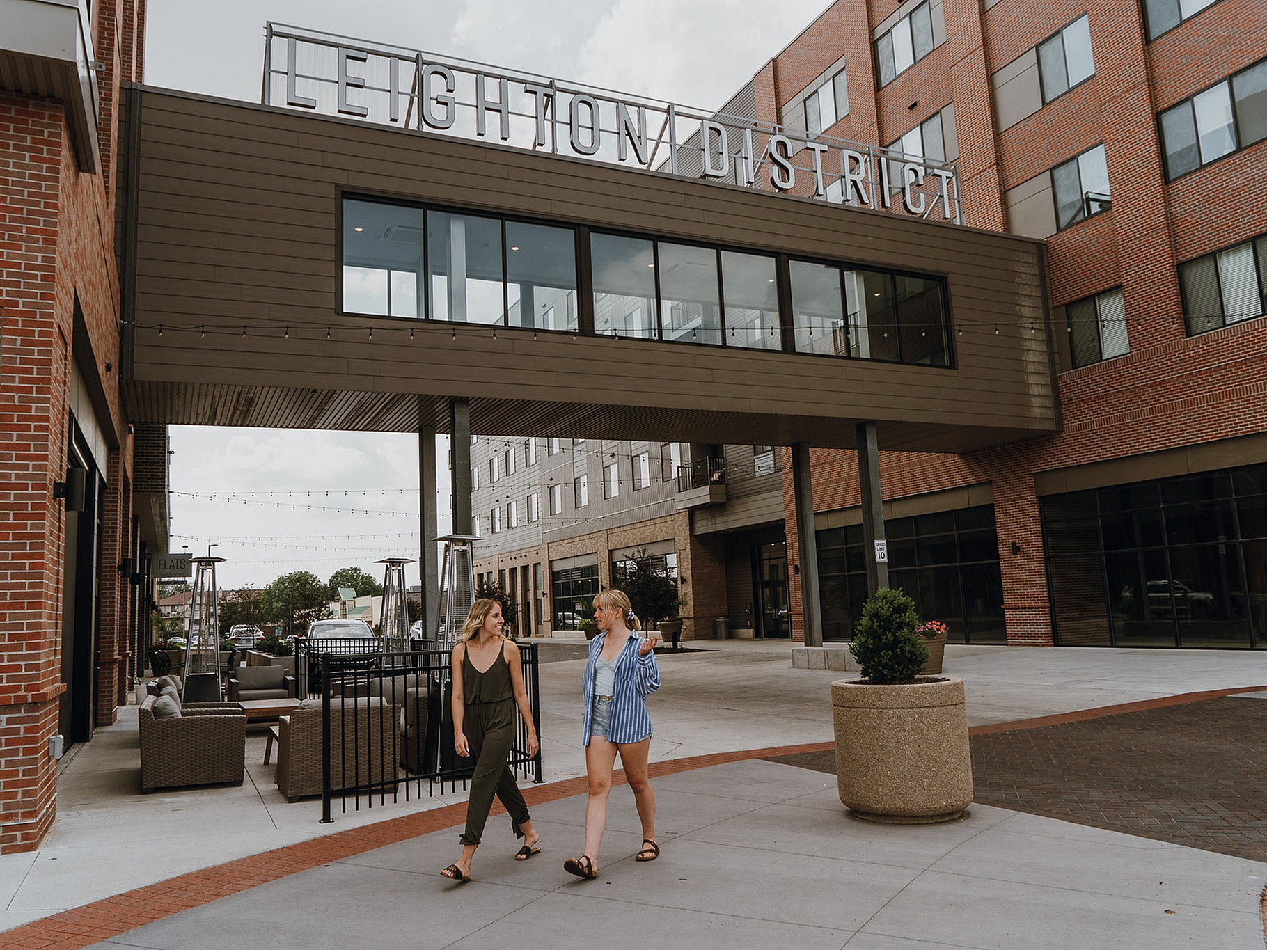 Modern urban living at Leighton District with stylish brick architecture and inviting outdoor seating, perfect for a vibrant lifestyle.
