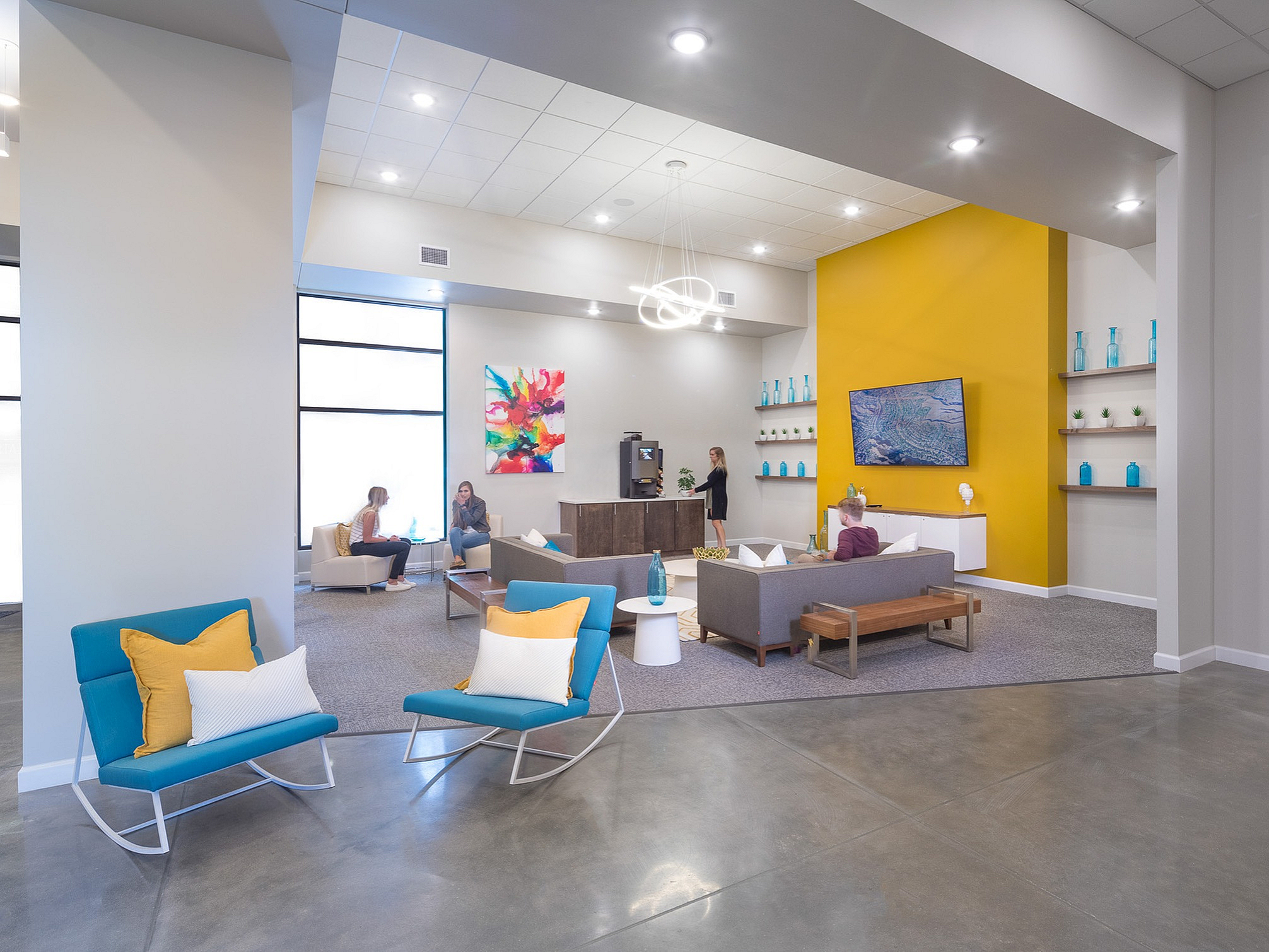 Modern, inviting lounge area featuring vibrant decor, comfortable seating, and a striking yellow accent wall perfect for socializing and relaxation.