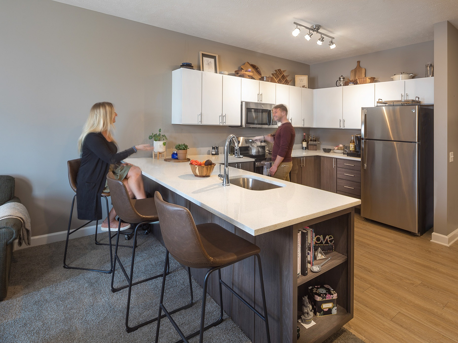 Modern kitchen with sleek countertops, stainless steel appliances, and stylish bar seating area.