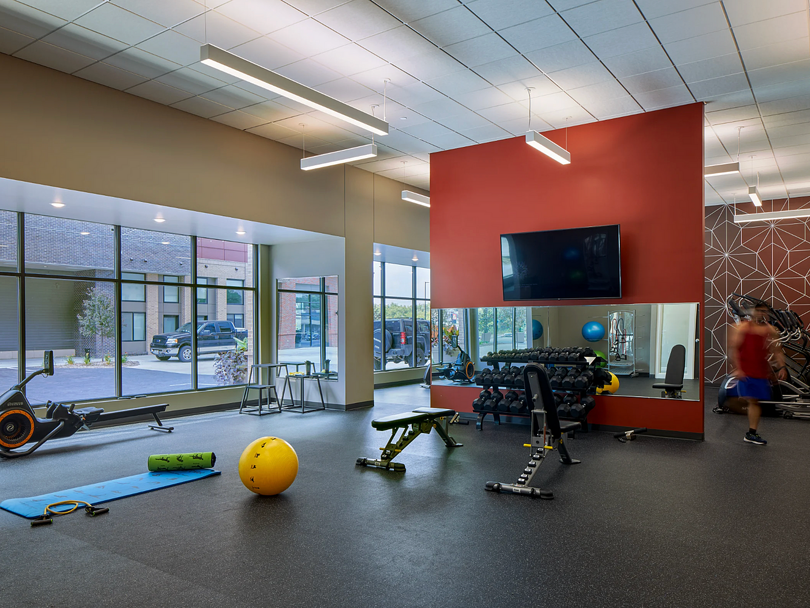 Modern fitness center featuring state-of-the-art workout equipment, large windows, and stylish design for an invigorating gym experience.