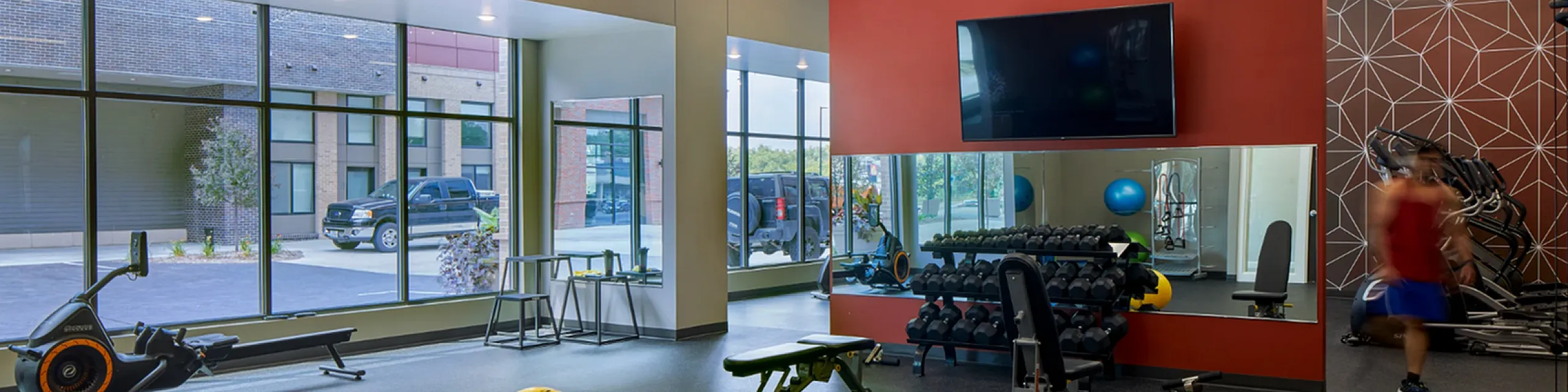 Modern fitness center with state-of-the-art equipment, large windows, and vibrant decor for an energizing workout experience.